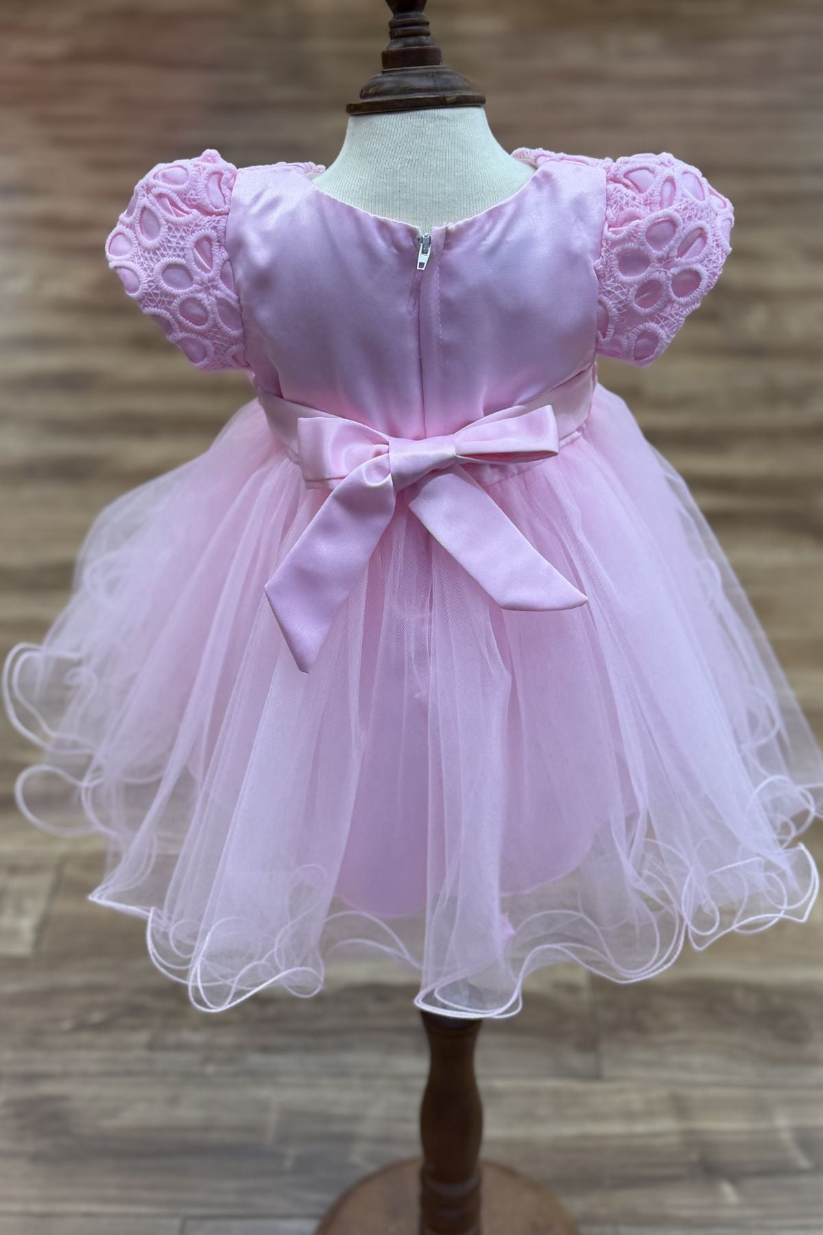 Pink flower girl dress back view highlighting full skirt and elegant silhouette.