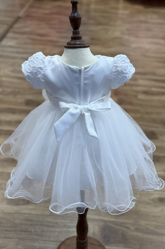 White dress back view highlighting voluminous tulle skirt and elegant silhouette