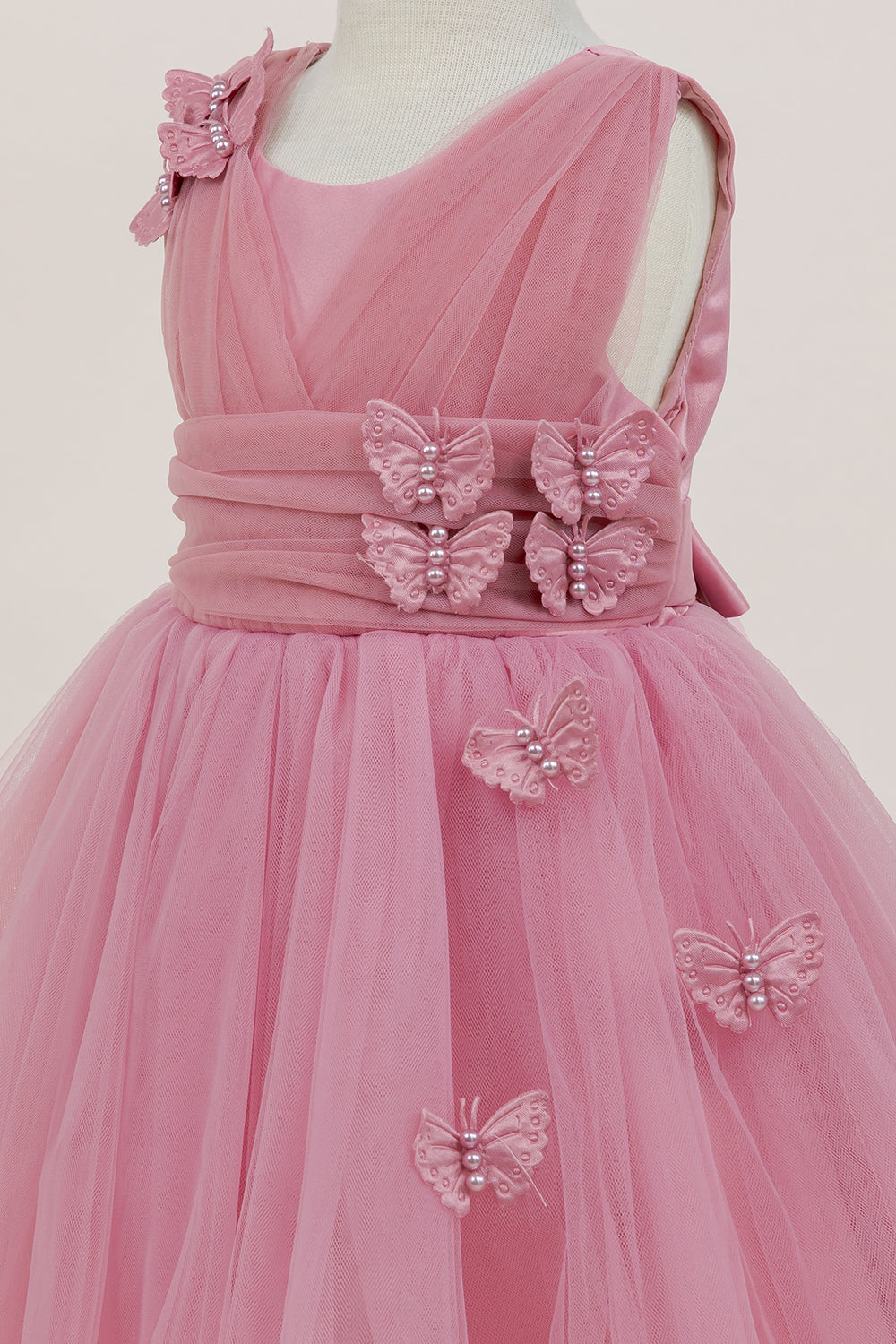 Close-up front view of rose dress showing shimmering fabric and bow accent