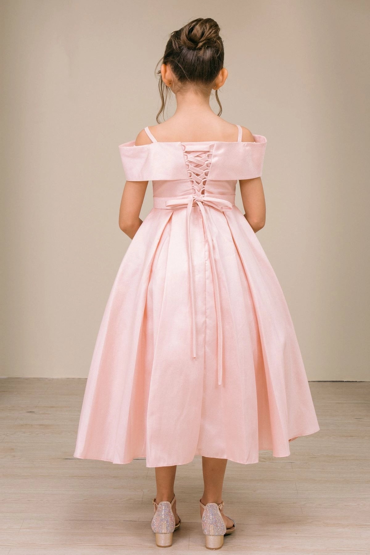 Detailed by back lacing and a waist sash, the Blush kids party dress reveals its construction.