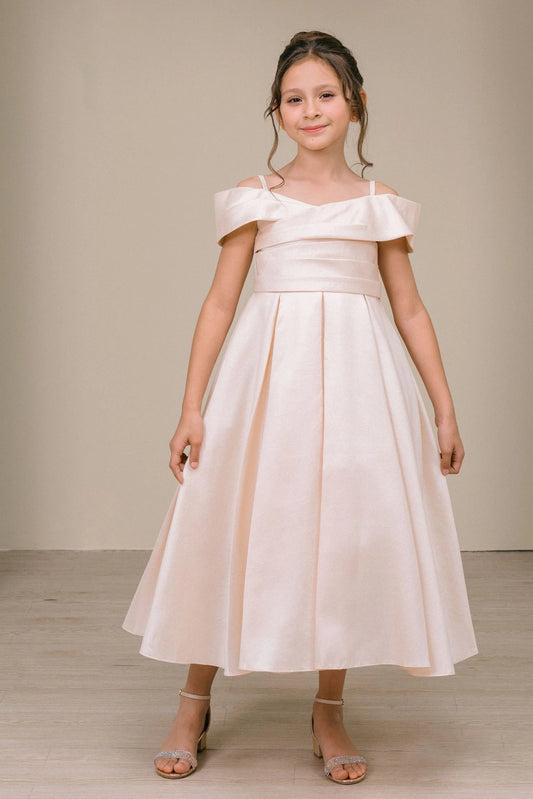 Showcasing with a folded off-shoulder neckline, this Champagne kids party dress displays elegant detail.