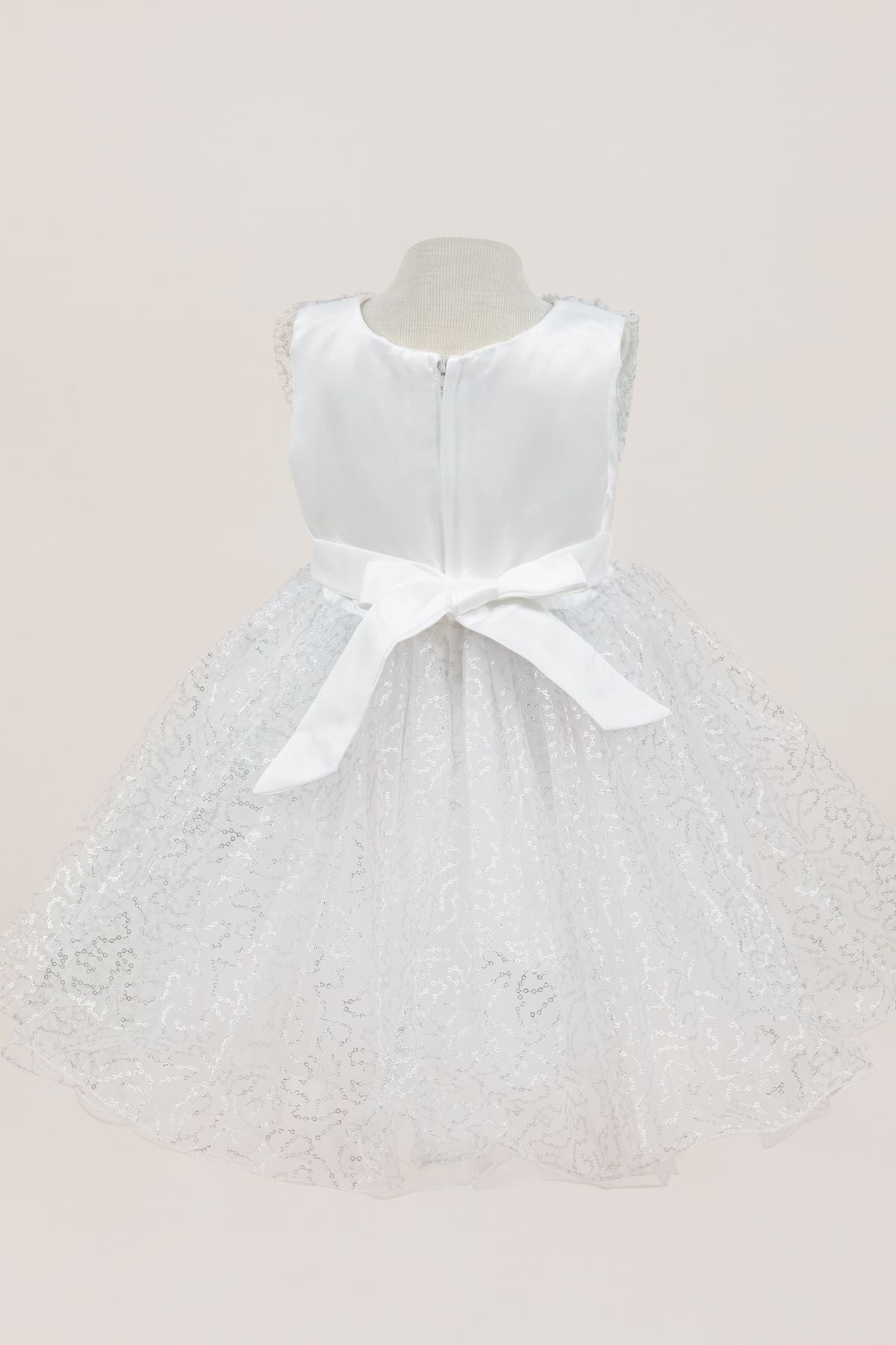 White flower girl dress back view highlighting full skirt and elegant silhouette.