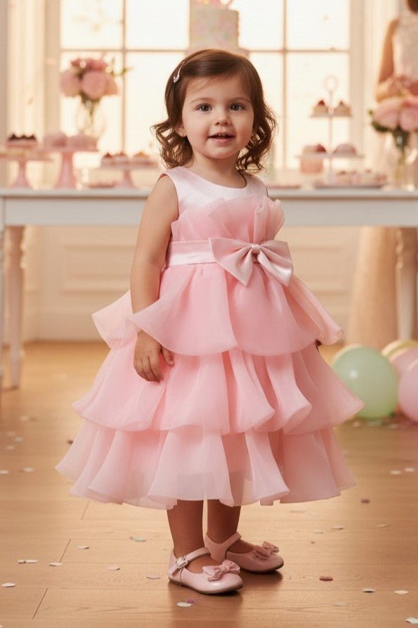 Peach flower girl Dress Front View With Layered Skirt And Oversized Bow Detail.