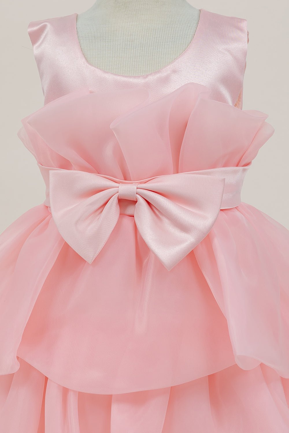 Close-up front view of lilac flower girl dress showing shimmering fabric and bow accent.