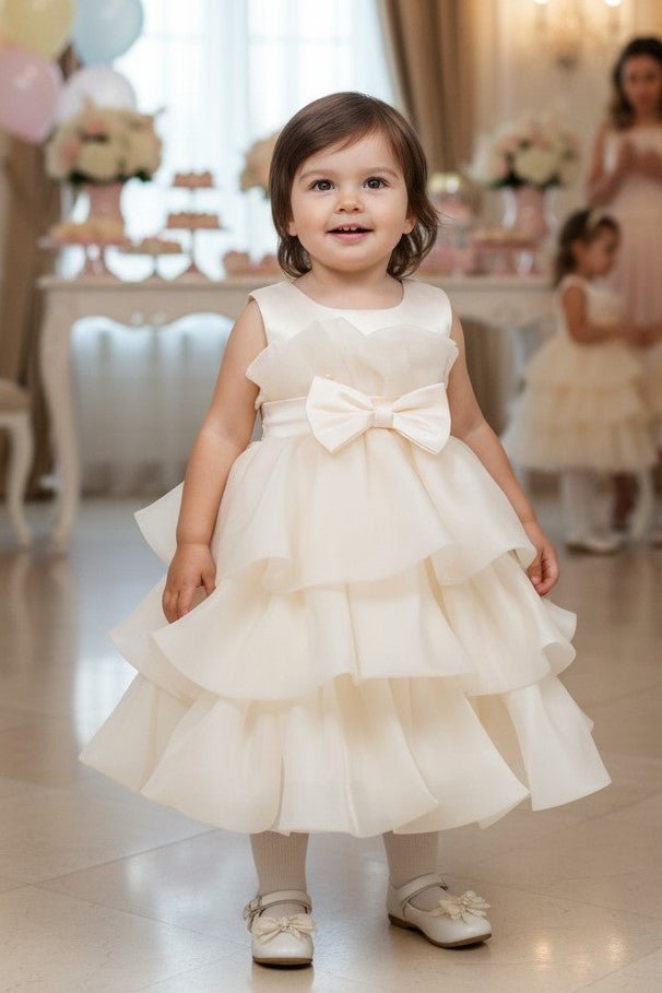 Champagne flower girl Dress Front View With Layered Skirt And Oversized Bow Detail.