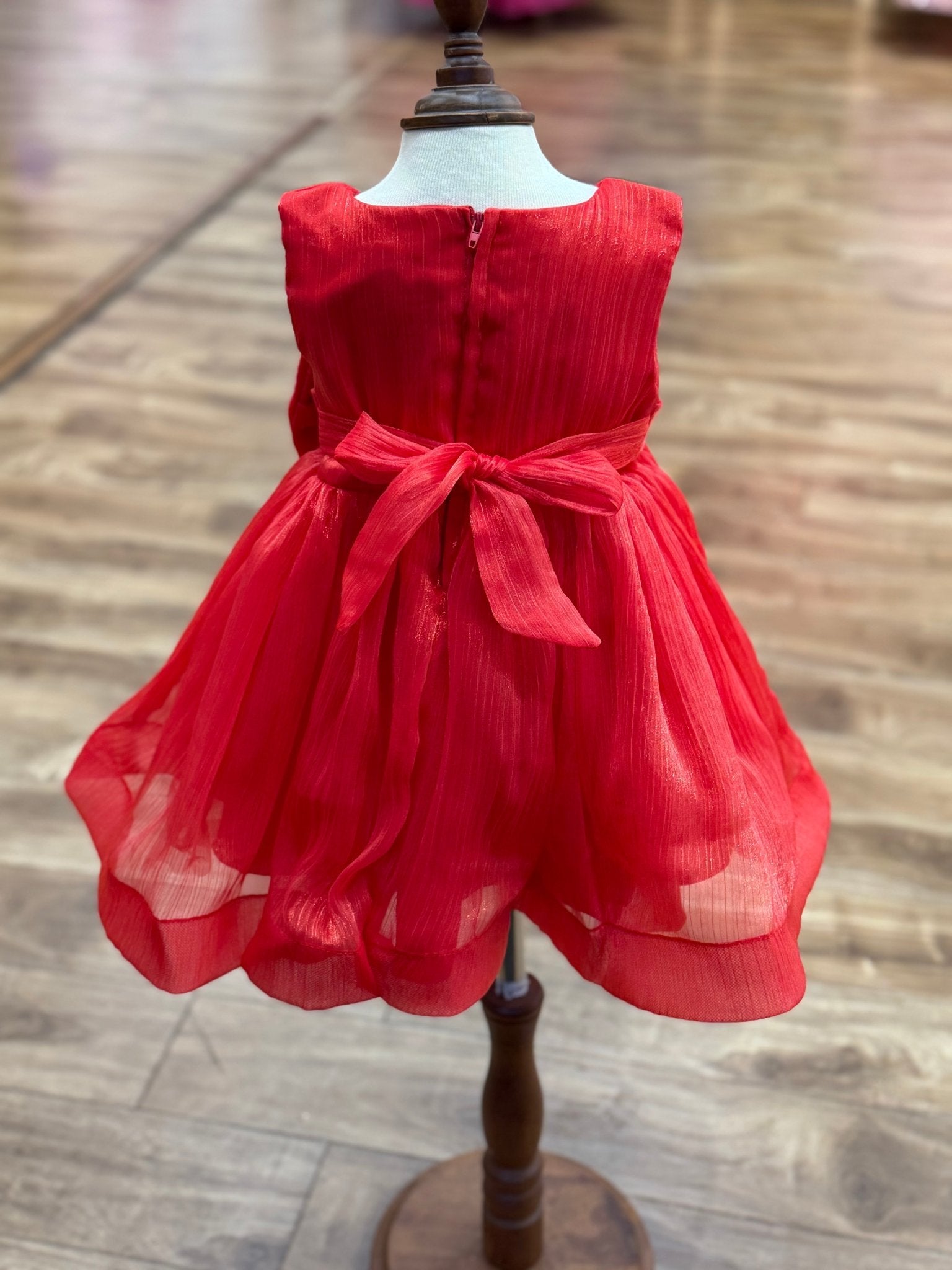 Red flower girl dress back view highlighting full skirt and elegant silhouette.