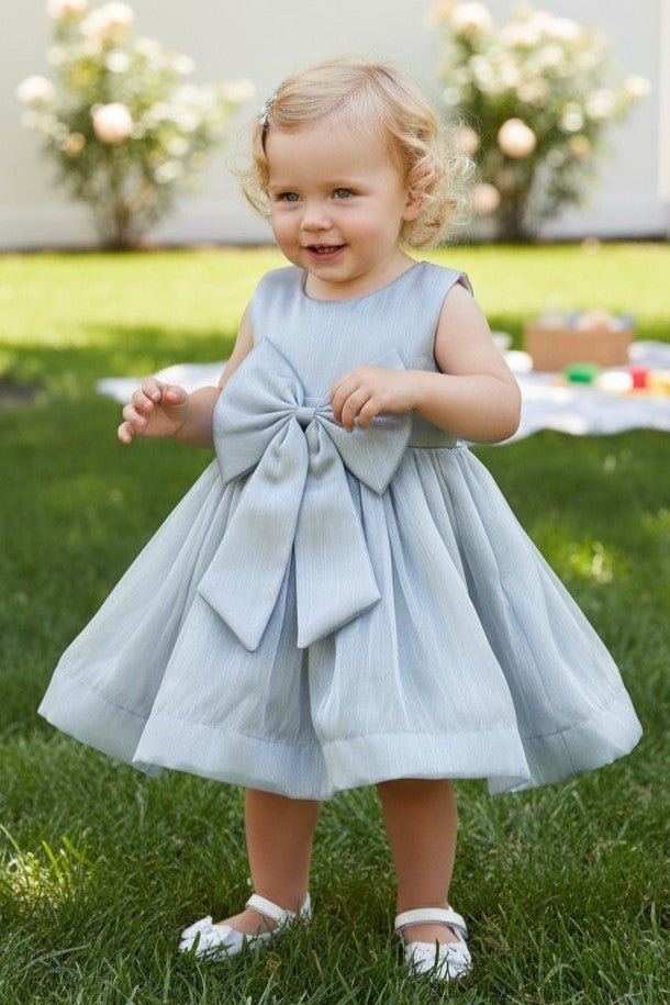 Silver flower girl Dress Front View With Layered Skirt And Oversized Bow Detail.