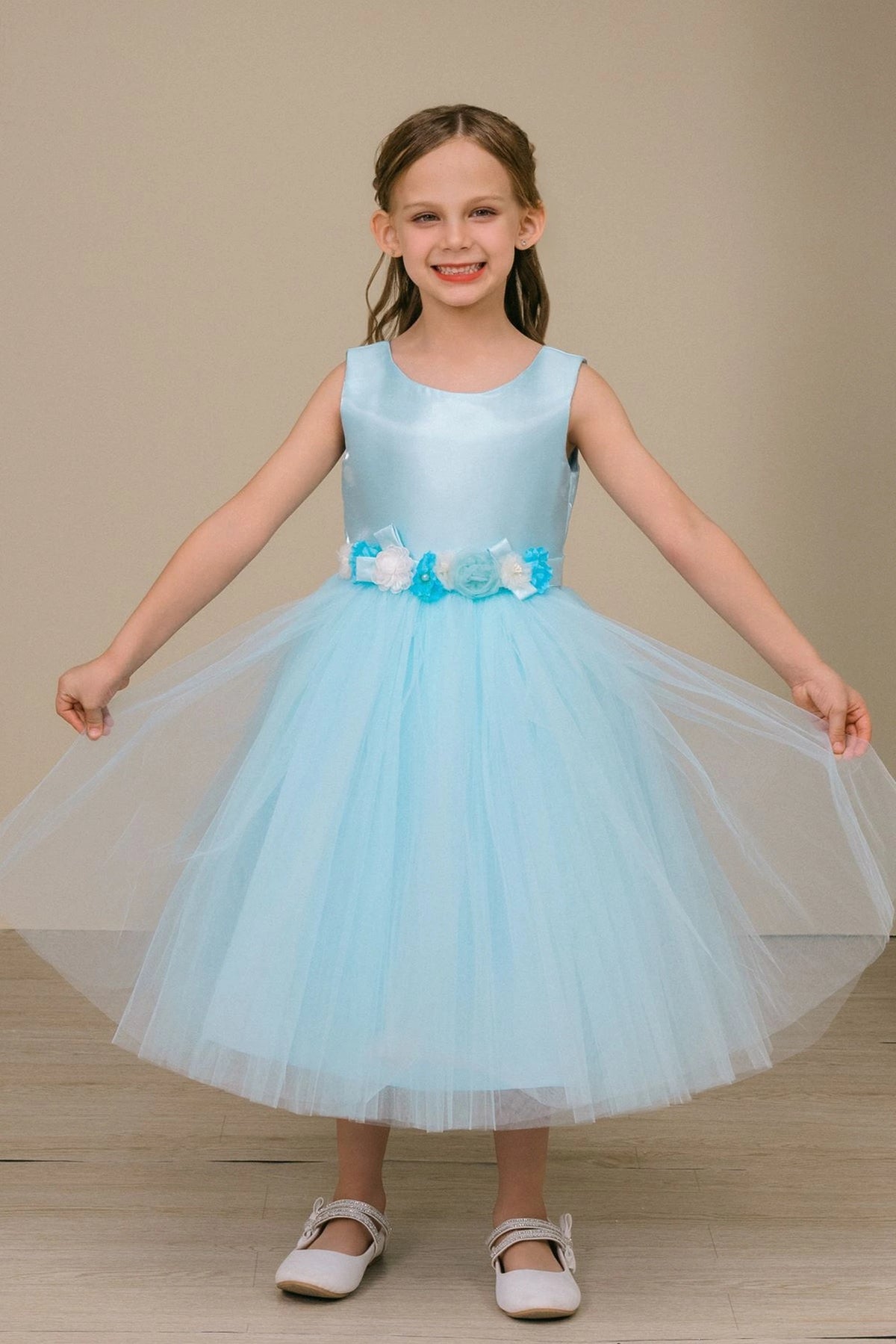 Blue flower girl dress features waist flowers above a full tulle skirt.