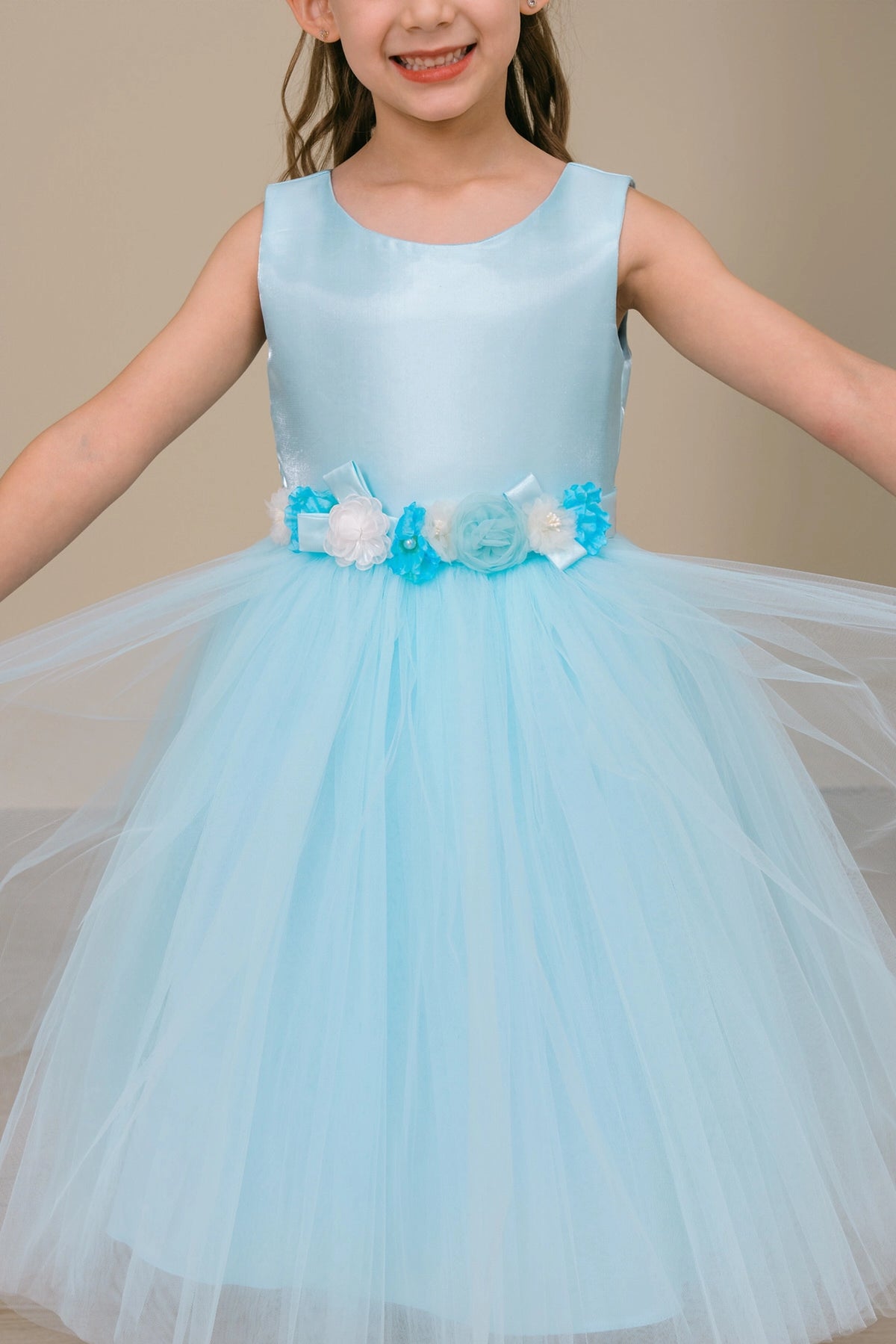 Visible on this Blue flower girl dress: dimensional flowers around the satin waist.
