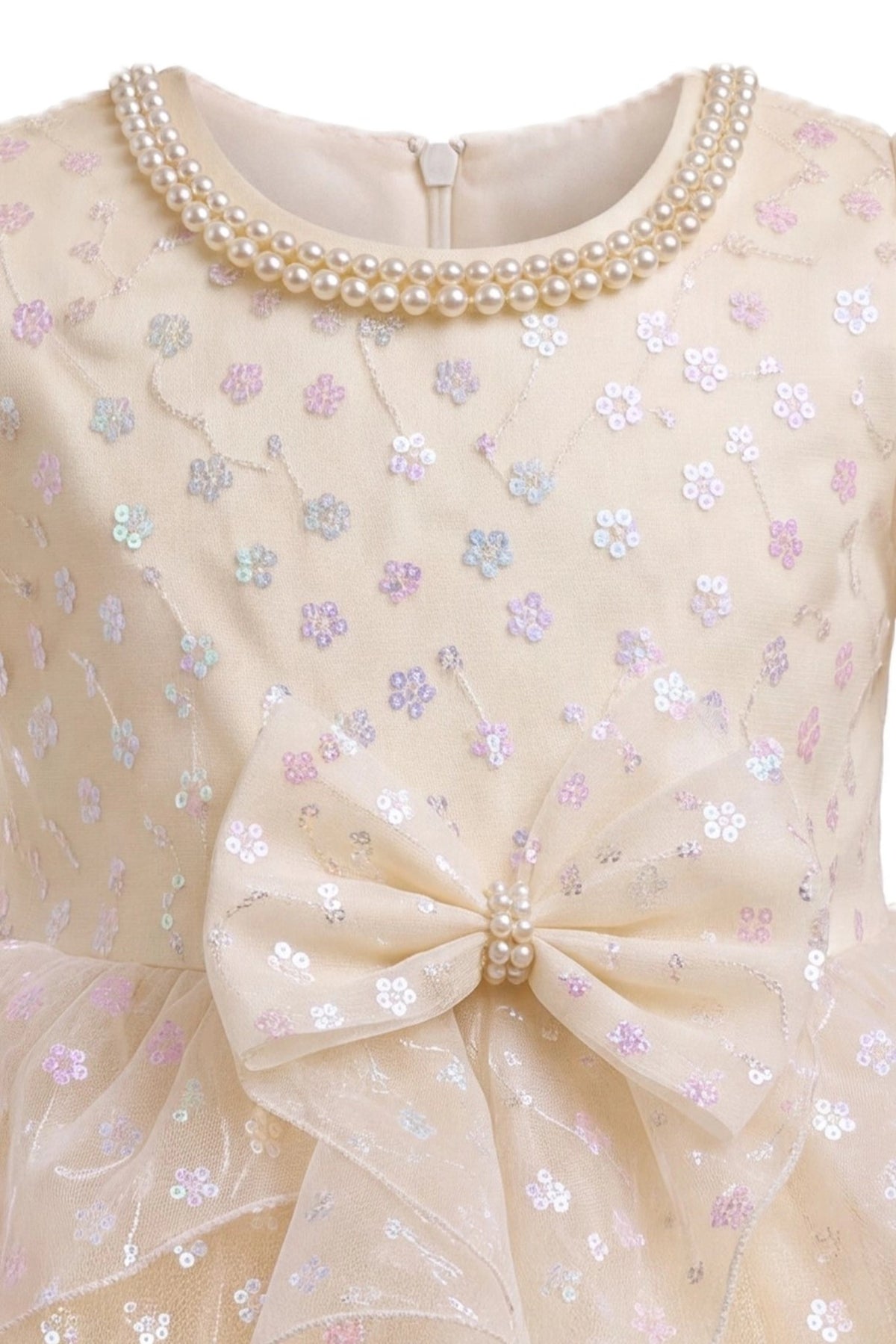 Detailed a flower-patterned waist bow complements the Champagne kids dress.