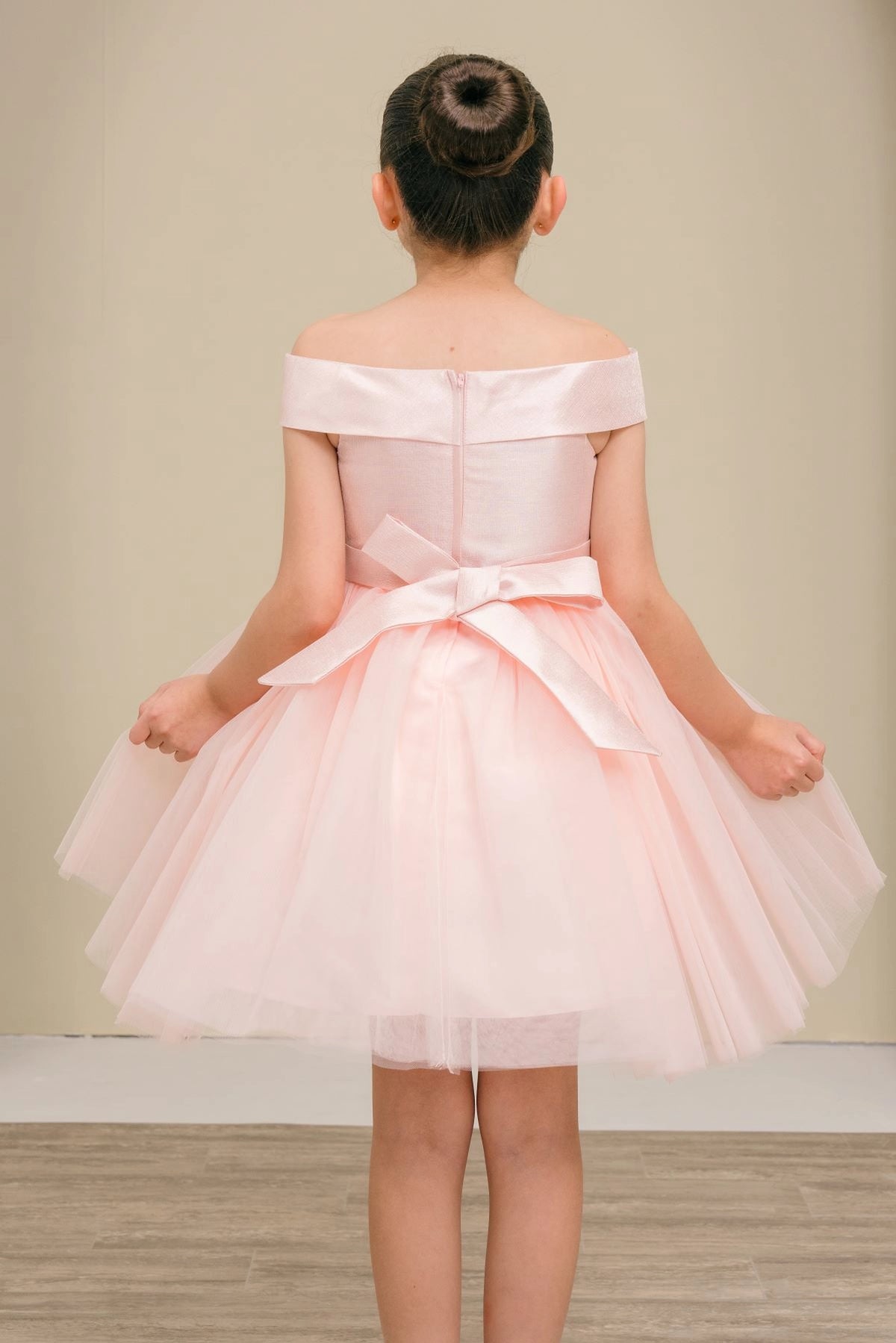 A Blush flower girl dress showing back sash bow above the tulle skirt.