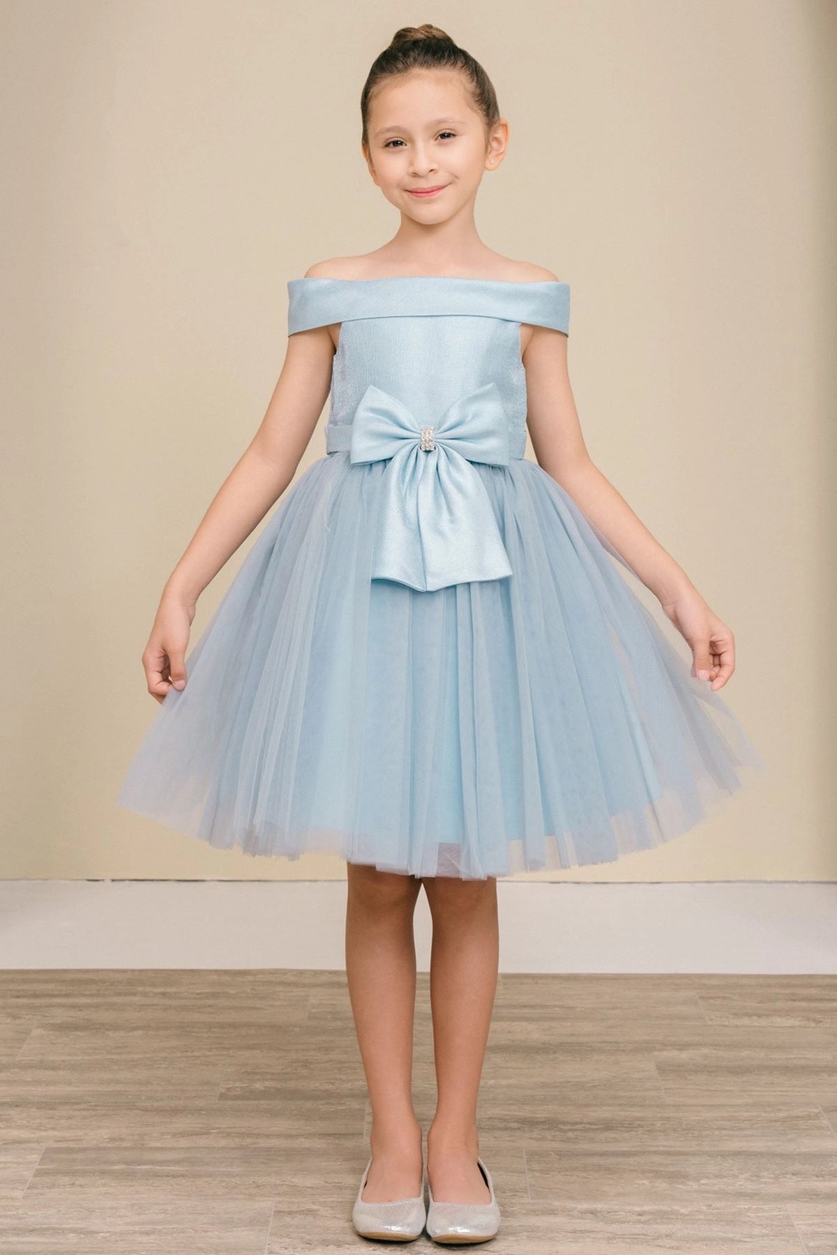 Dusty Blue flower girl dress features large bow above a layered tulle skirt.