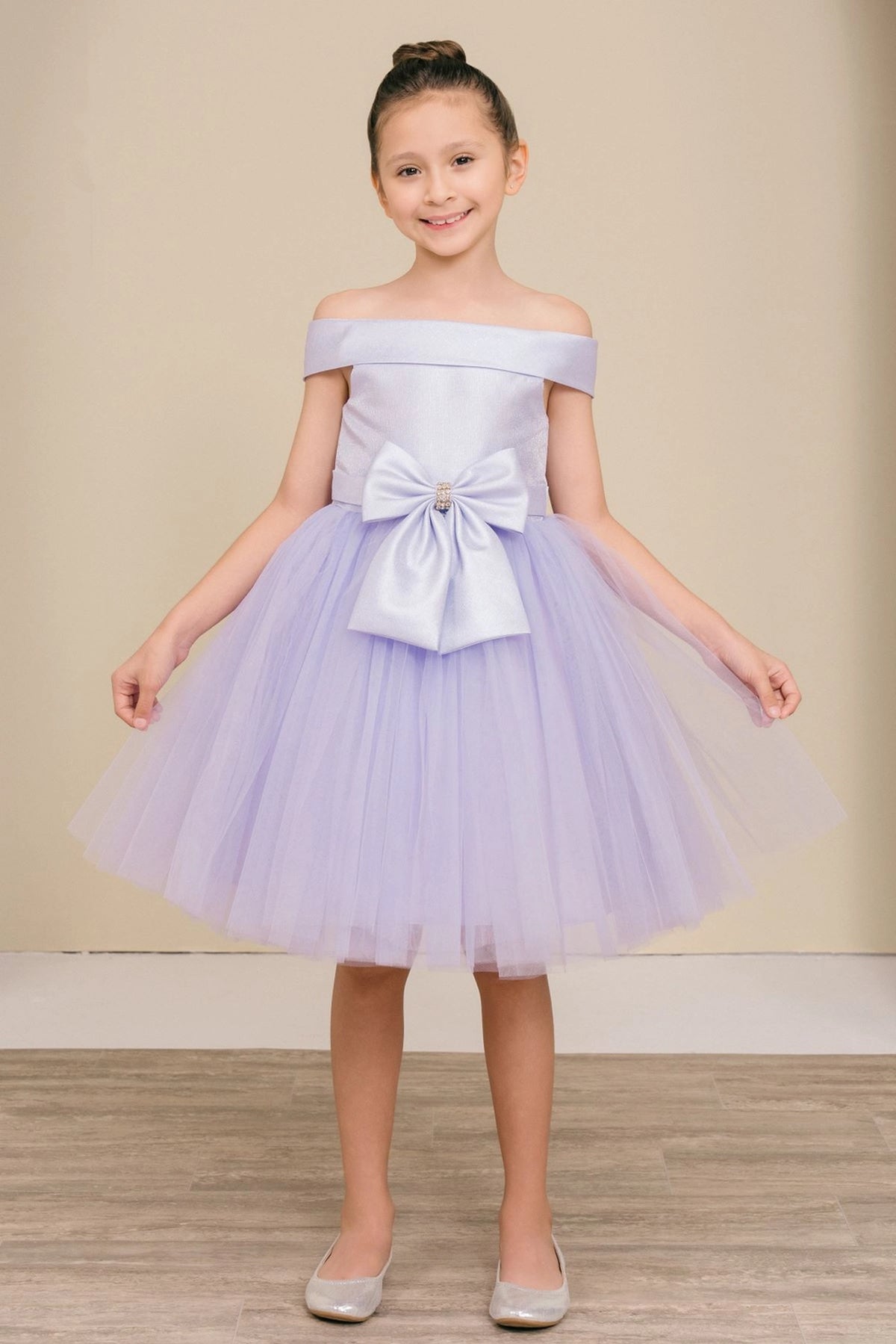Lilac flower girl dress features off-shoulder satin bodice above the tulle skirt.