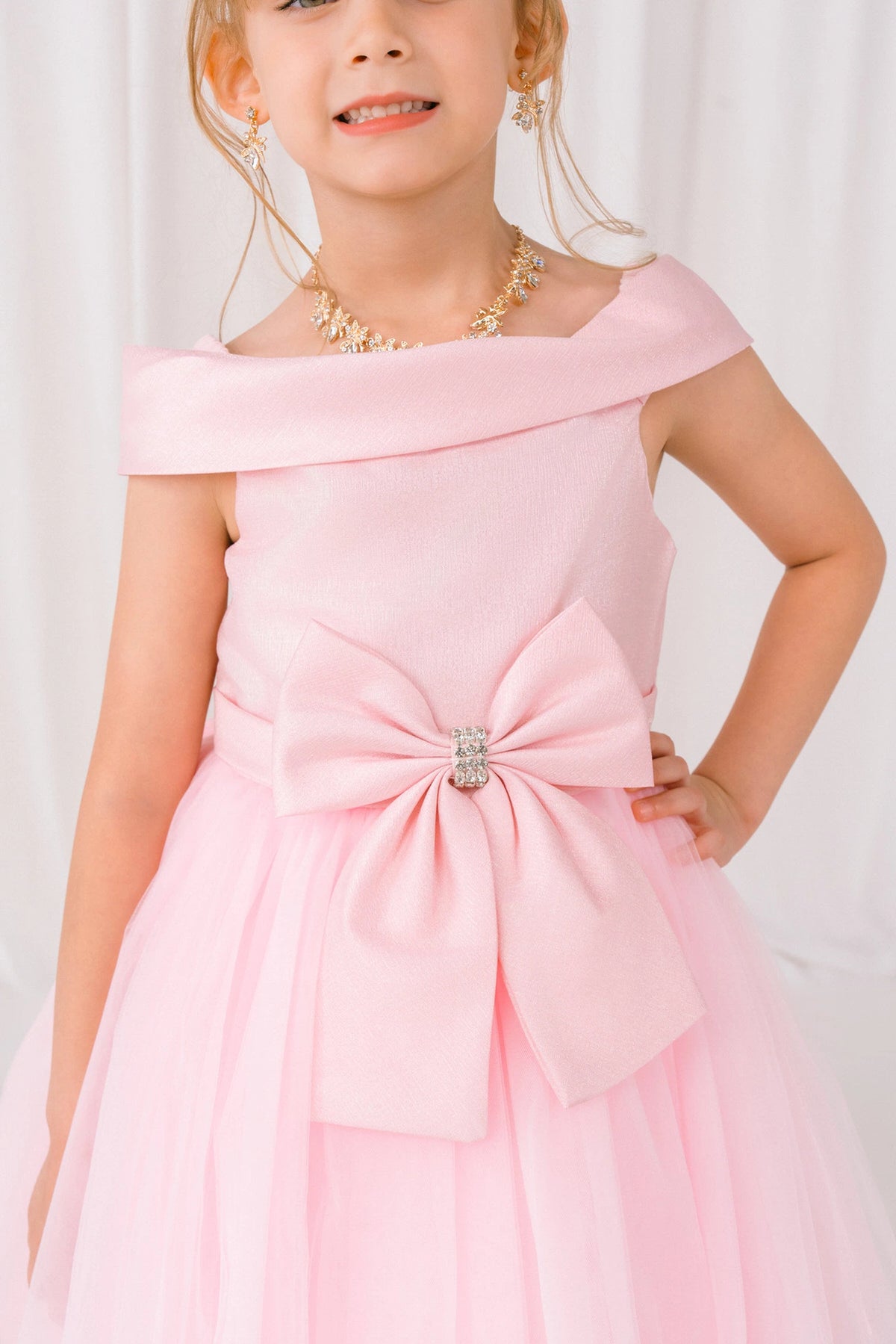 Visible on this Pink flower girl dress: large front bow with crystal-like center.