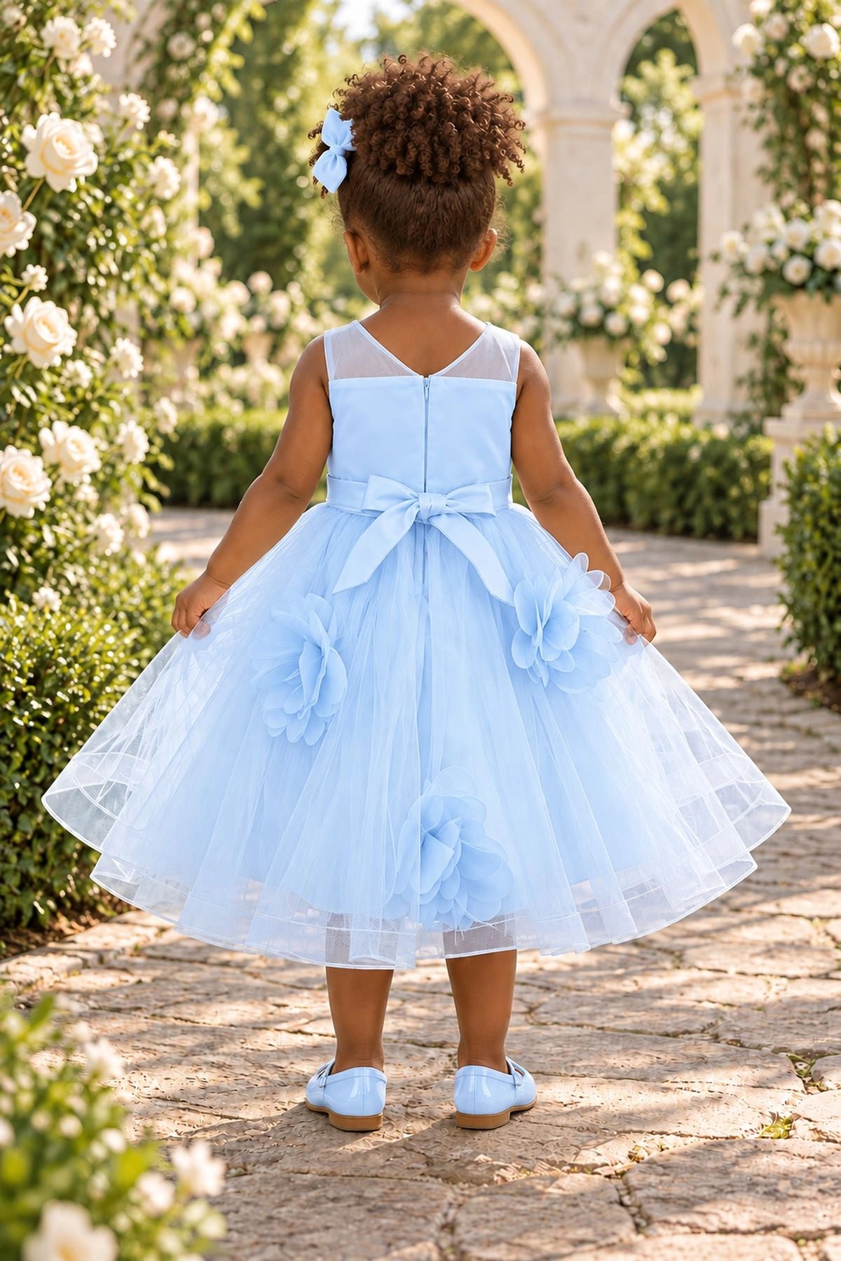 Tied at the back, the Blue kids dress features a large bow.