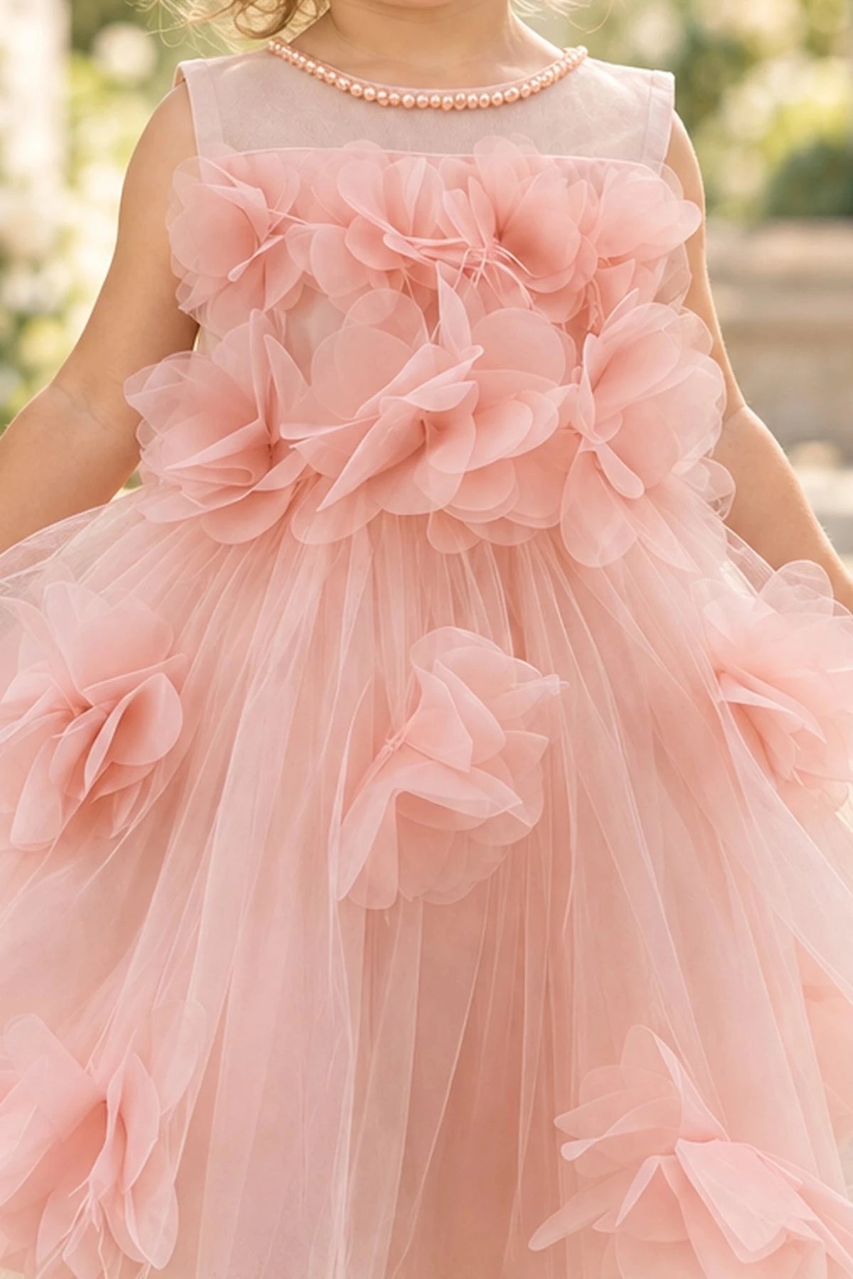 Detailed a sheer upper neckline complements the Blush kids dress.