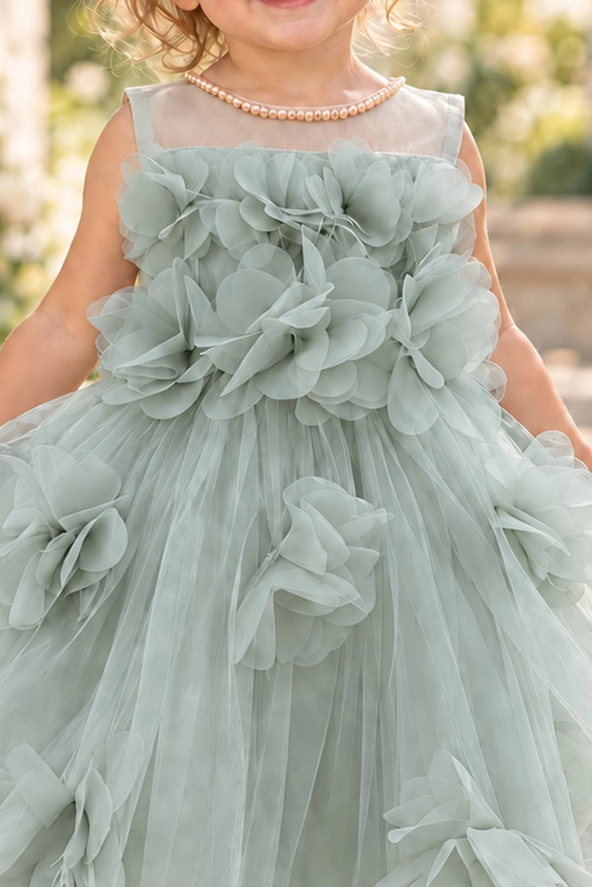 Detailed a sheer upper neckline complements the Sage kids dress.