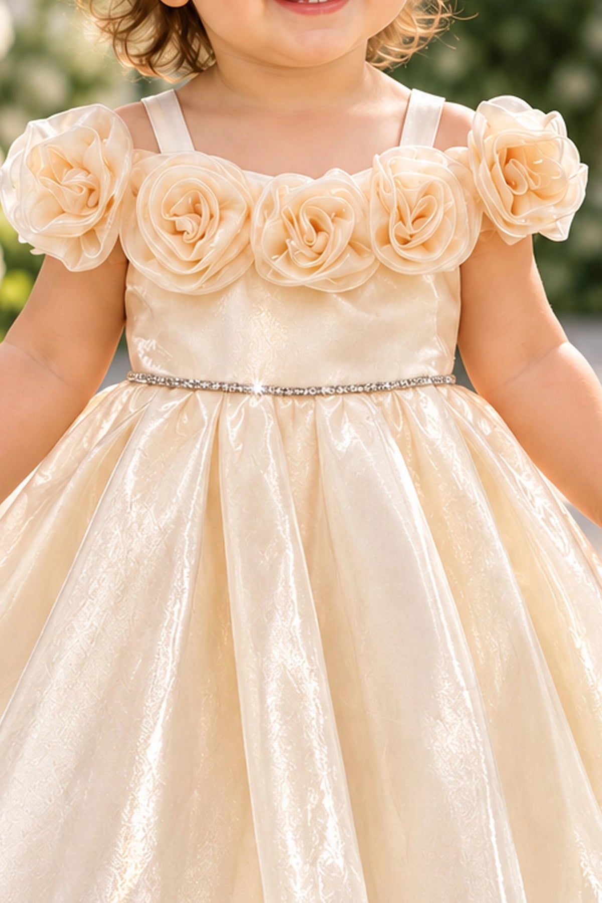 Layered shaping highlights rosettes framing the neckline on the Champagne kids dress.