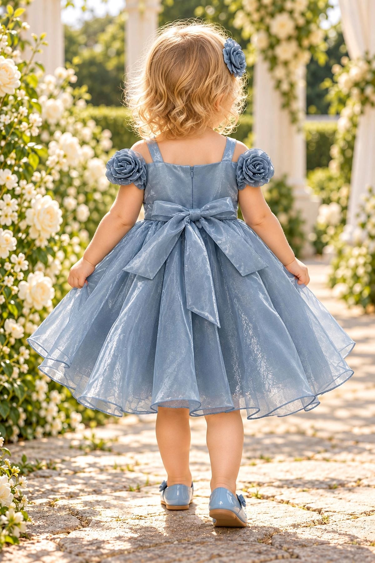 Tied at the back, the Dusty Blue kids dress features a large bow.