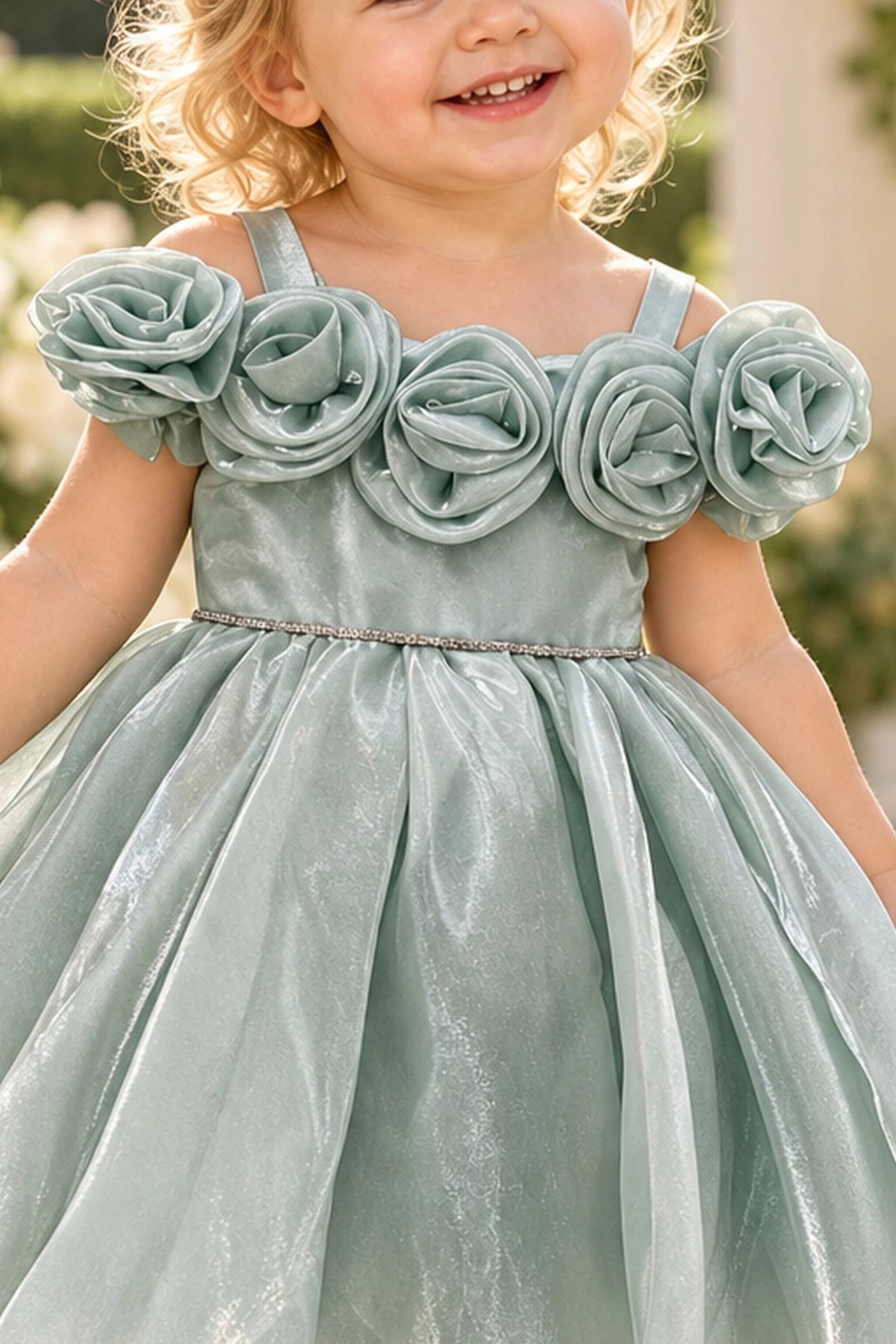 Layered shaping highlights rosettes framing the neckline on the Sage kids dress.