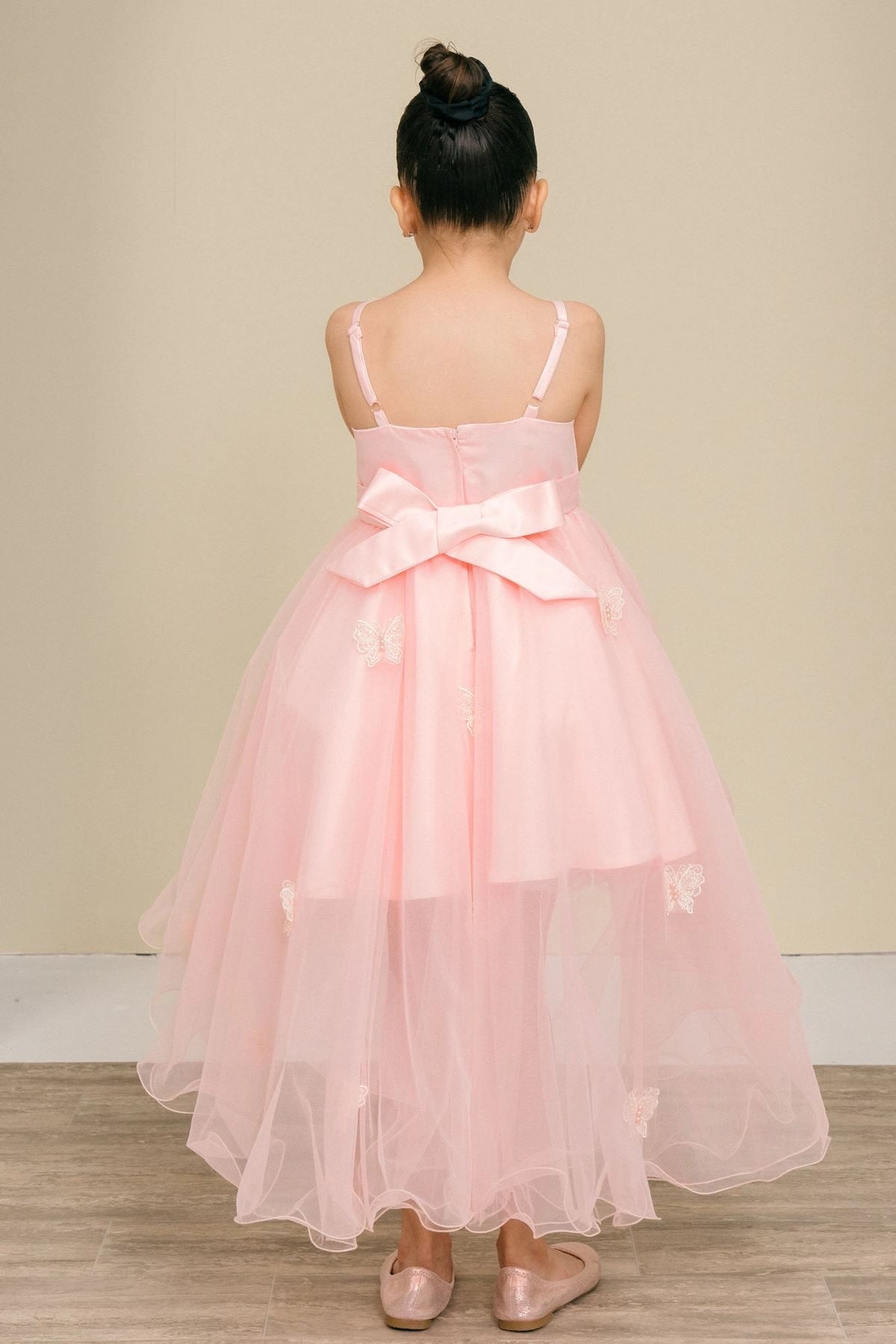 Finished details of a large bow above a high-low skirt distinguish the Blush kids party dress.