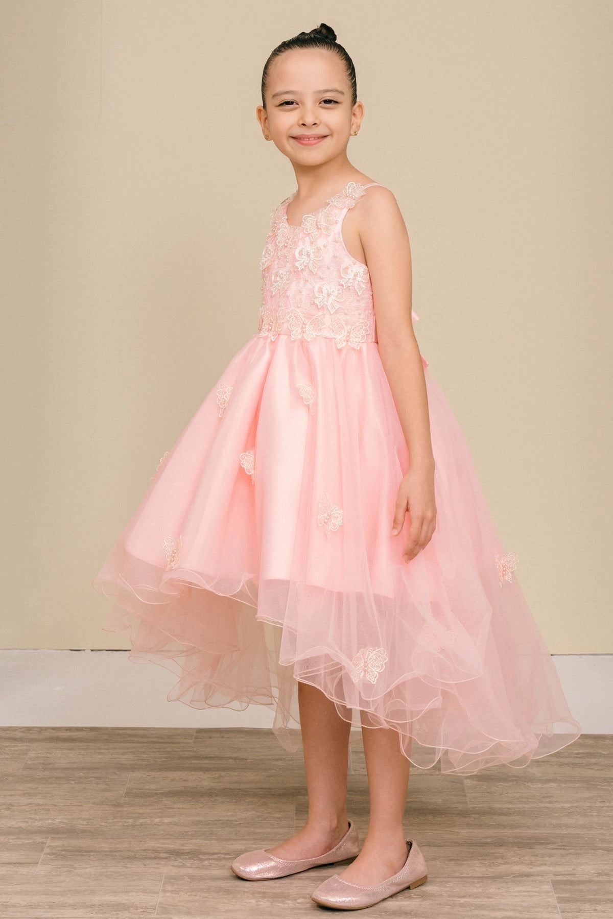 Designed details of three-dimensional bodice flowers distinguish the Blush kids party dress.