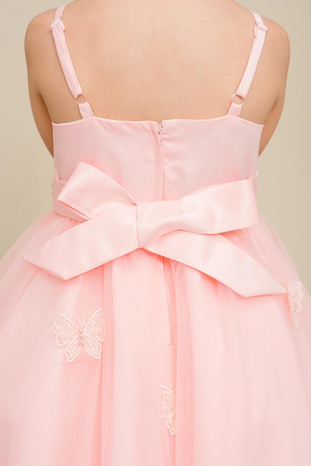 Detailed by a large bow above a high-low skirt, the Blush kids party dress reveals its construction.