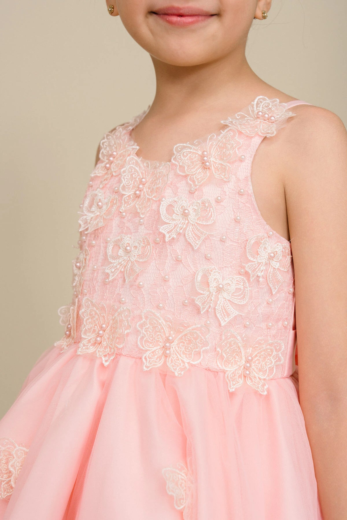 Accented a tiered high-low skirt adds character to this Blush kids party dress.