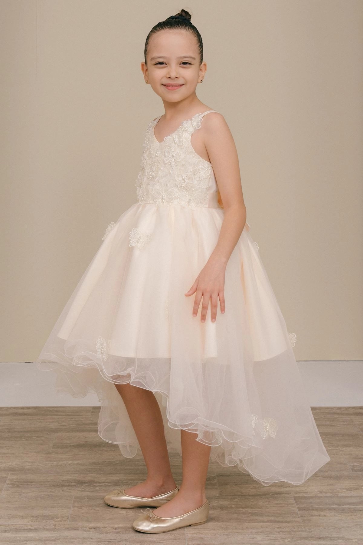 Featuring with three-dimensional bodice flowers, this Champagne kids party dress displays elegant detail.
