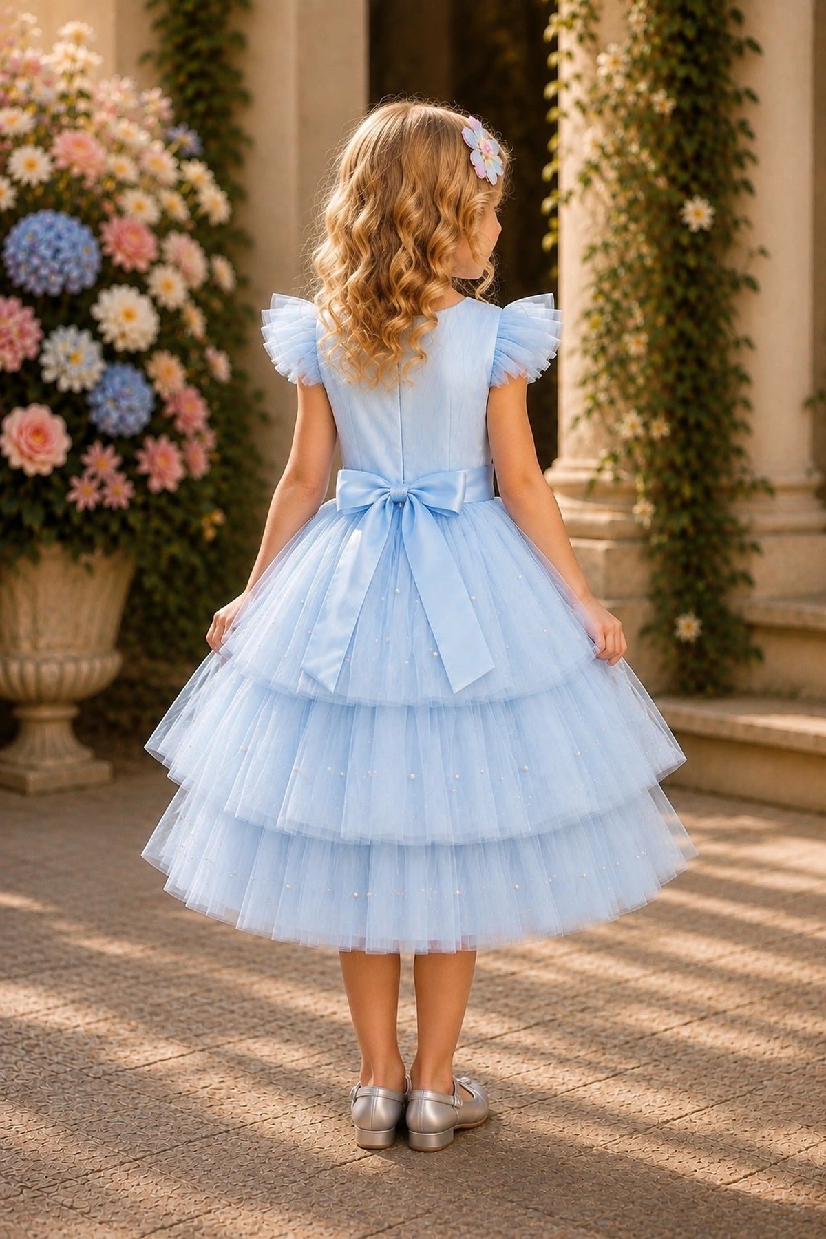 Tied at the back, the Blue kids dress features a large bow.