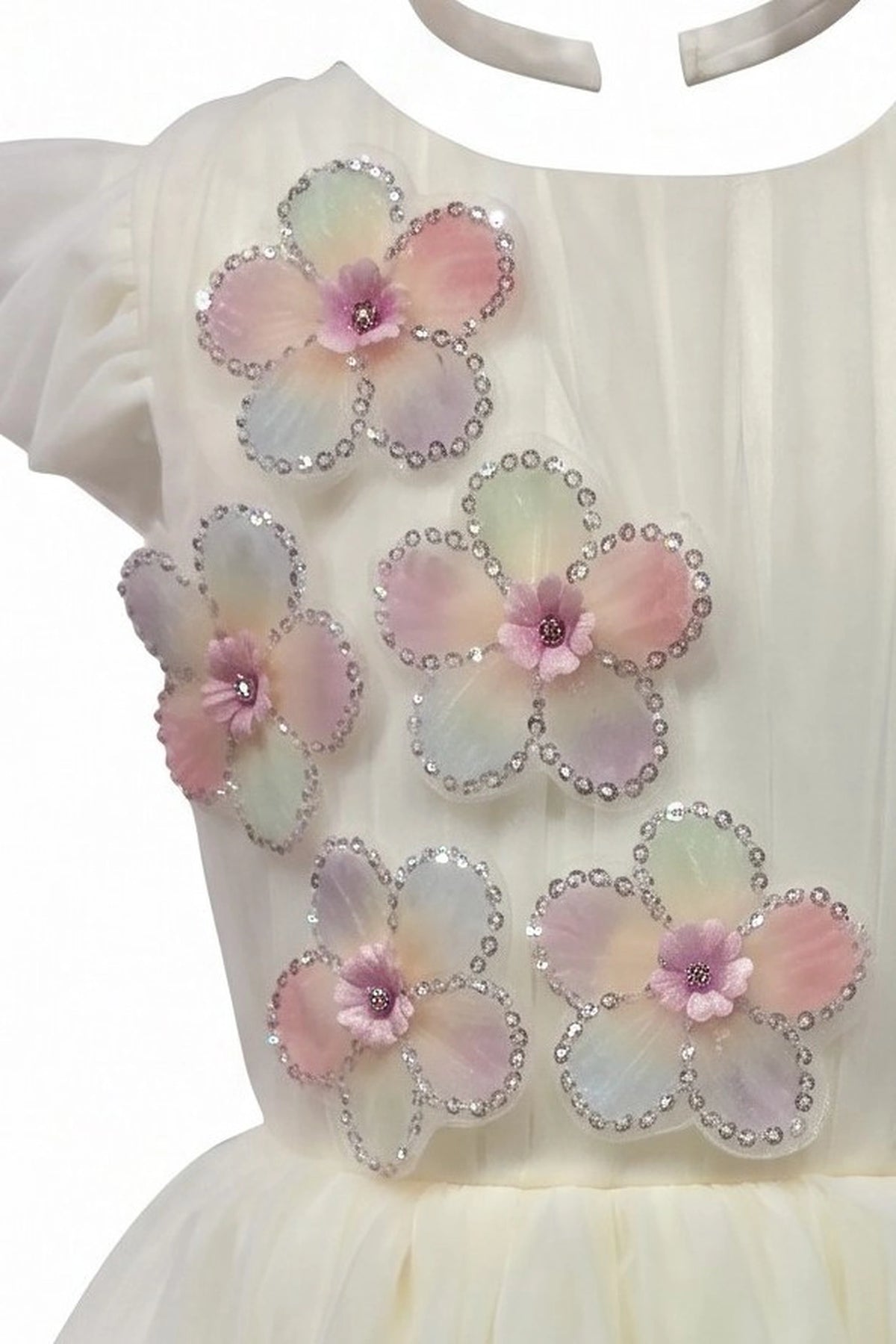 Detailed a tiered pearl-dotted skirt complements the Champagne kids dress.