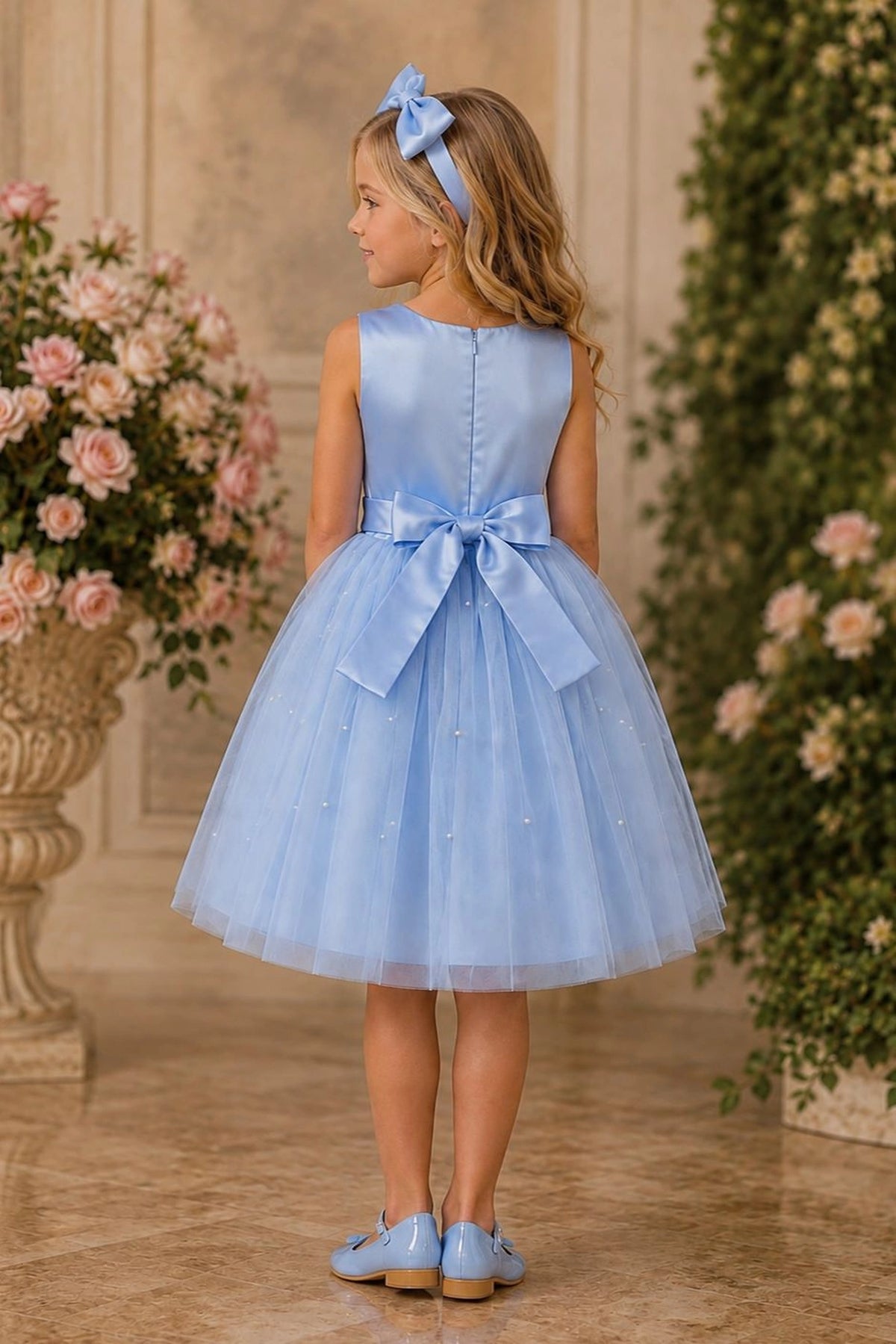 Tied at the back, the Blue kids dress features a large bow.