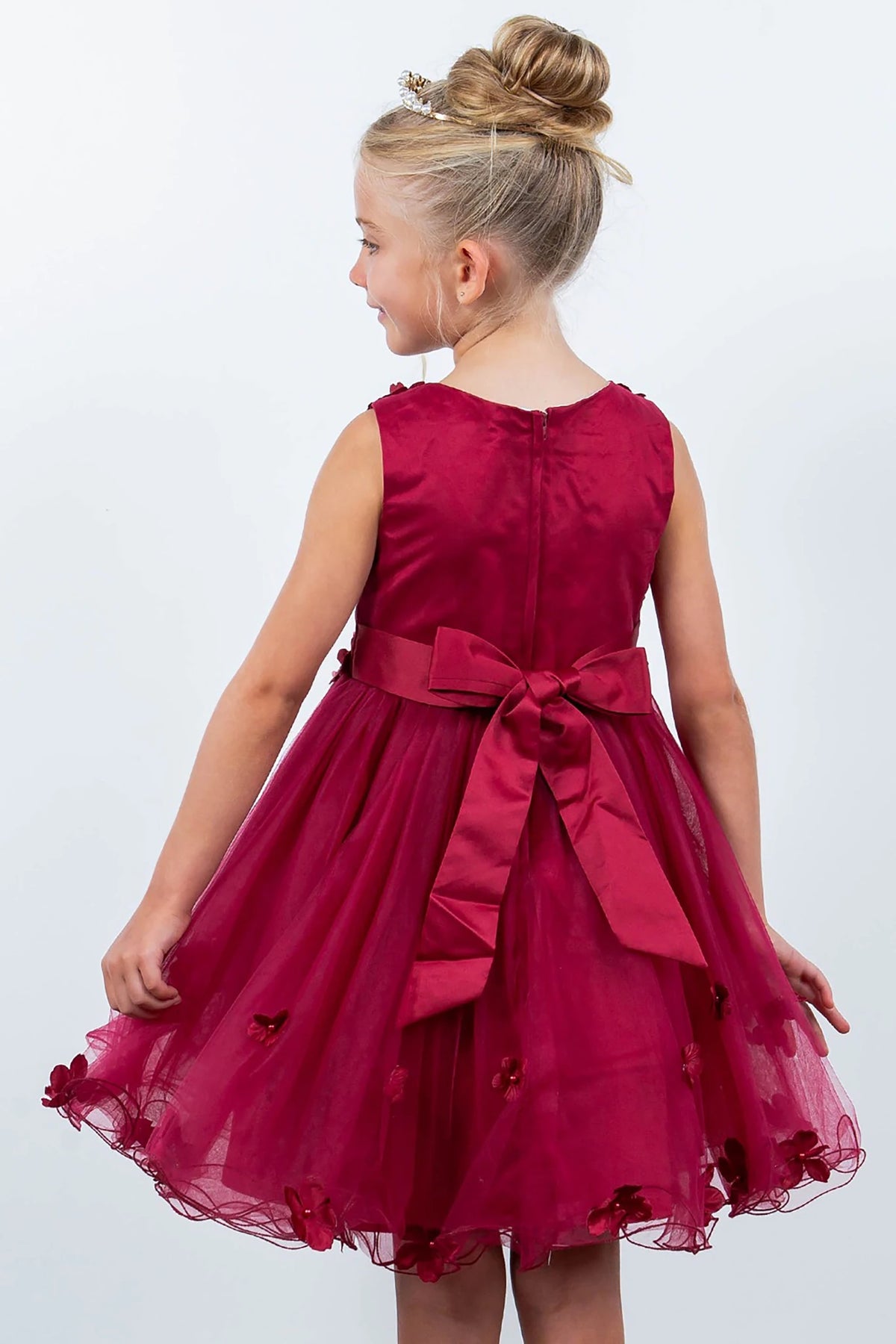 A burgundy flower girl dress with a bow.