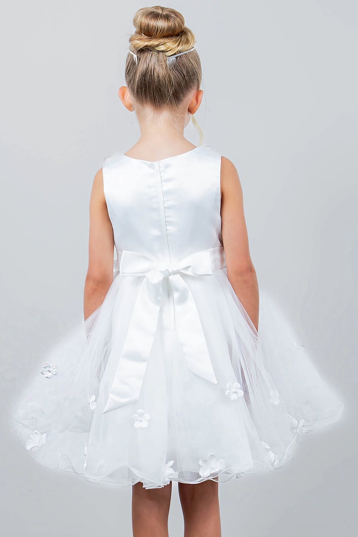 A white flower girl dress with a bow.