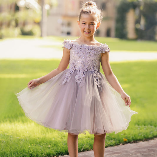 Young girl in a floral dress standing outdoors on a sunny day
