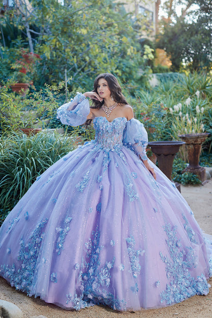 Quinceanera | Detachable Puff Sleeves and Cape Sparkly Ball Gown | Lilac Two Tone 3D Floral Detail Quince Dress - front view of woman wearing dress with one hand under her chin