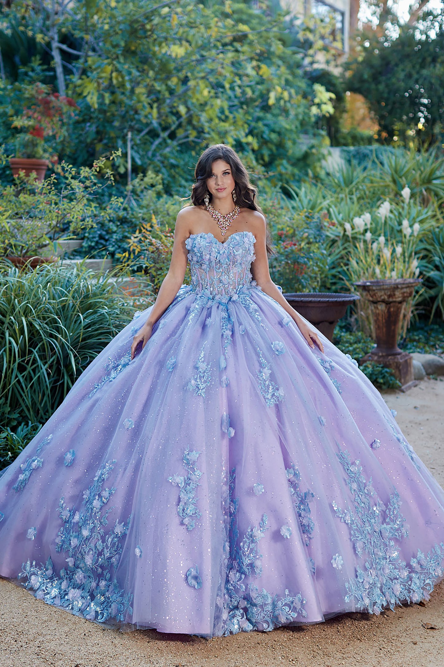 Quinceanera | Detachable Puff Sleeves and Cape Sparkly Ball Gown | Lilac Two Tone 3D Floral Detail Quince Dress - front view of woman wearing dress with hands at her sides