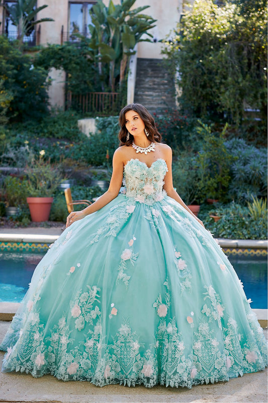 Quinceanera | Mint See-through 3D Flowers, Embroidery, Bead bodice and Glitter Tulle Ballgown w/ detachable Big Bow - front view of woman wearing dress staring off into the distance