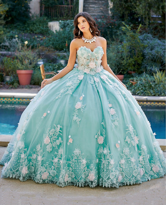 Quinceanera | Mint See-through 3D Flowers, Embroidery, Bead bodice and Glitter Tulle Ballgown w/ detachable Big Bow - front view of woman wearing dress staring off into the distance