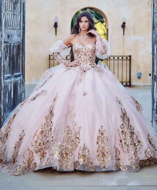 Quinceanera | Detachable Puffy Sleeve Champagne Ballgown | Gold Embroidered and Sequin Bodice Quince dress - front view of woman wearing dress with one hand by neck and the other hand on waist