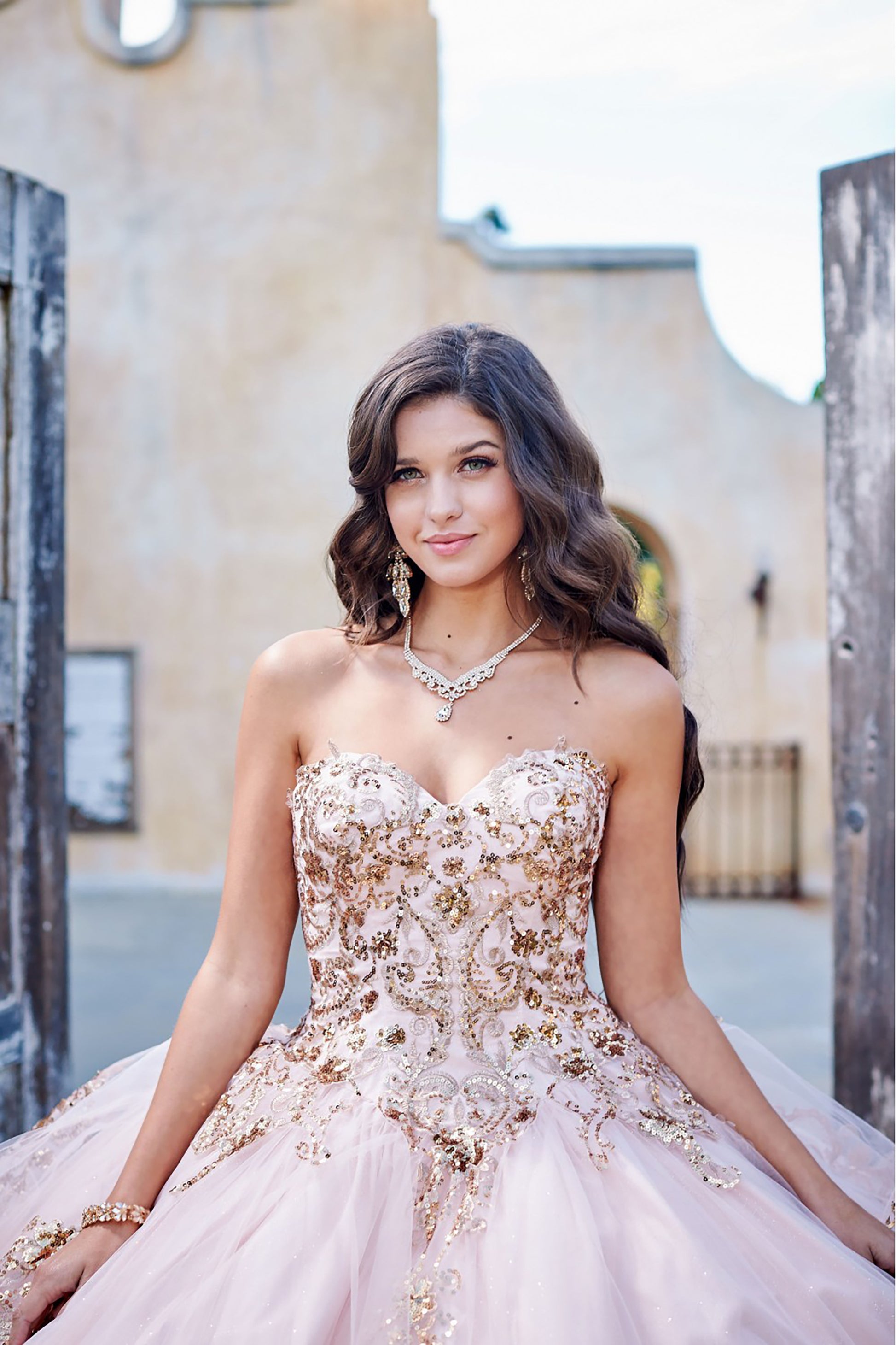 Quinceanera | Detachable Puffy Sleeve Champagne Ballgown | Gold Embroidered and Sequin Bodice Quince dress - zoomed in front view of woman wearing dress and smiling