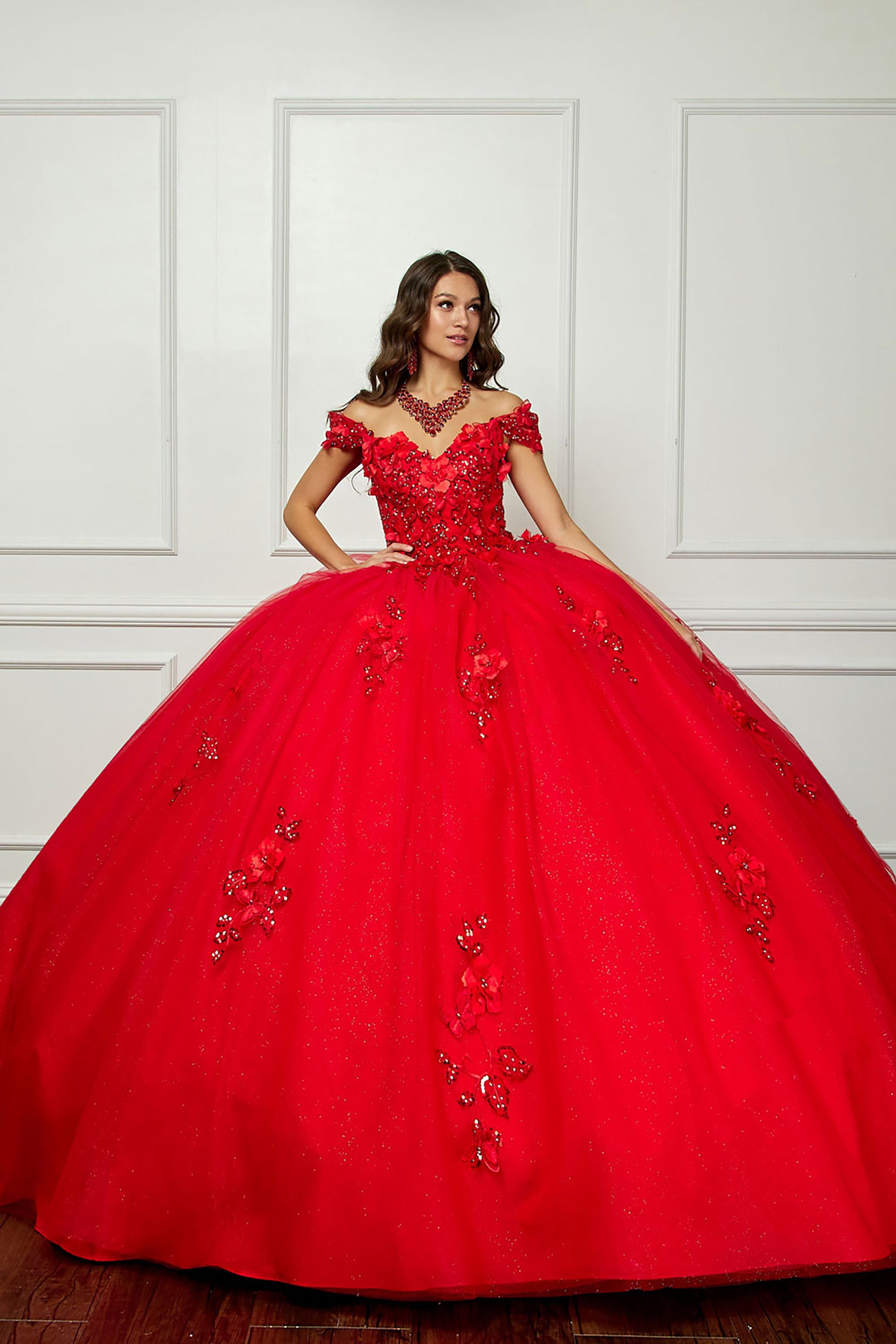 Red Long Train Off-Shoulder Sequin detail 3D Flower and Butterflies bodice with Sparkle Tulle Quince Dress - front view of woman wearing dress with one hand on her hip