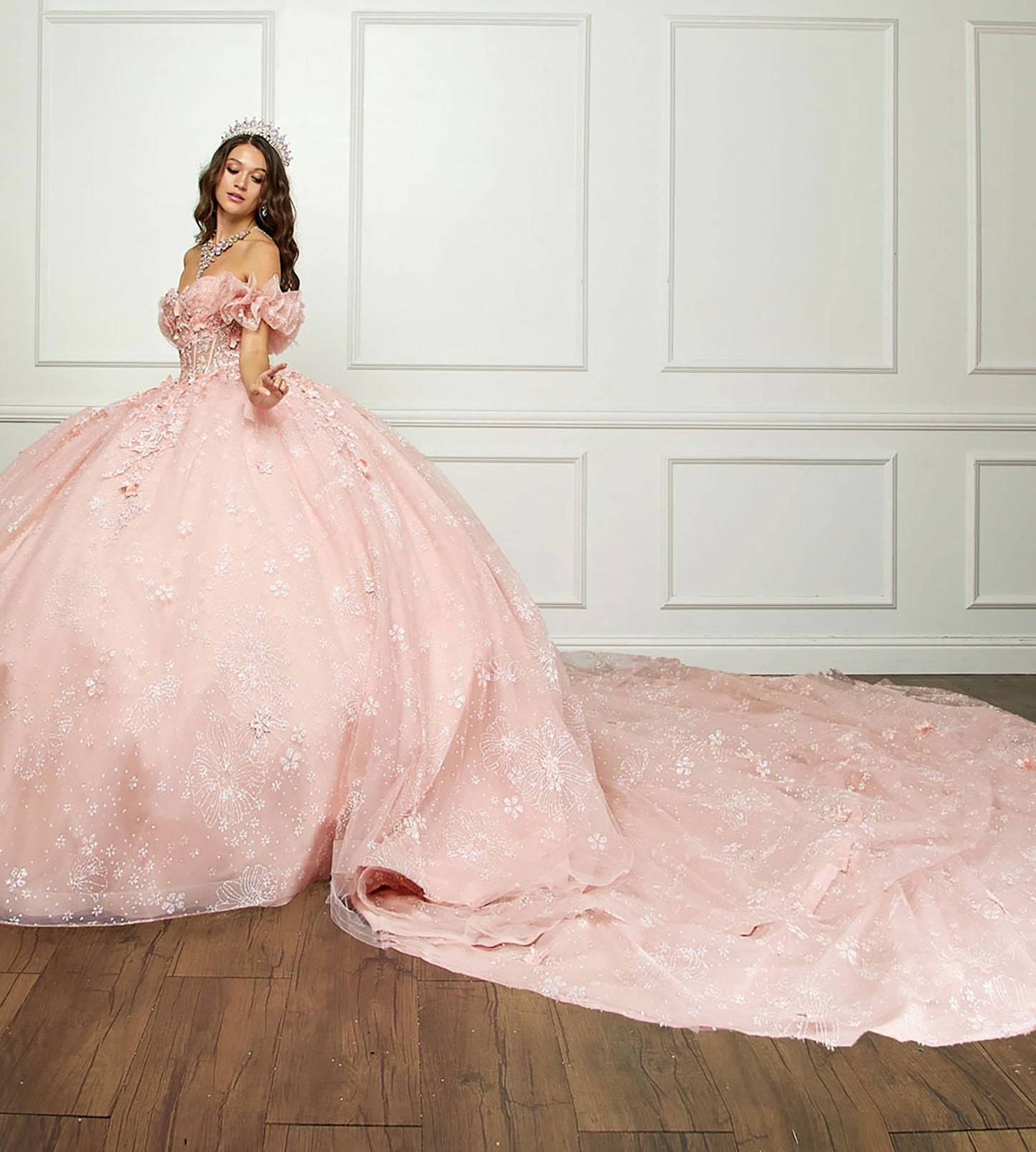 Quinceañera | Long Train, 3D Flowers, Rhinestones w/ Embroidered See-through Bodice Quince dress | Detachable Ruffle Sleeves - full side view of woman wearing dress