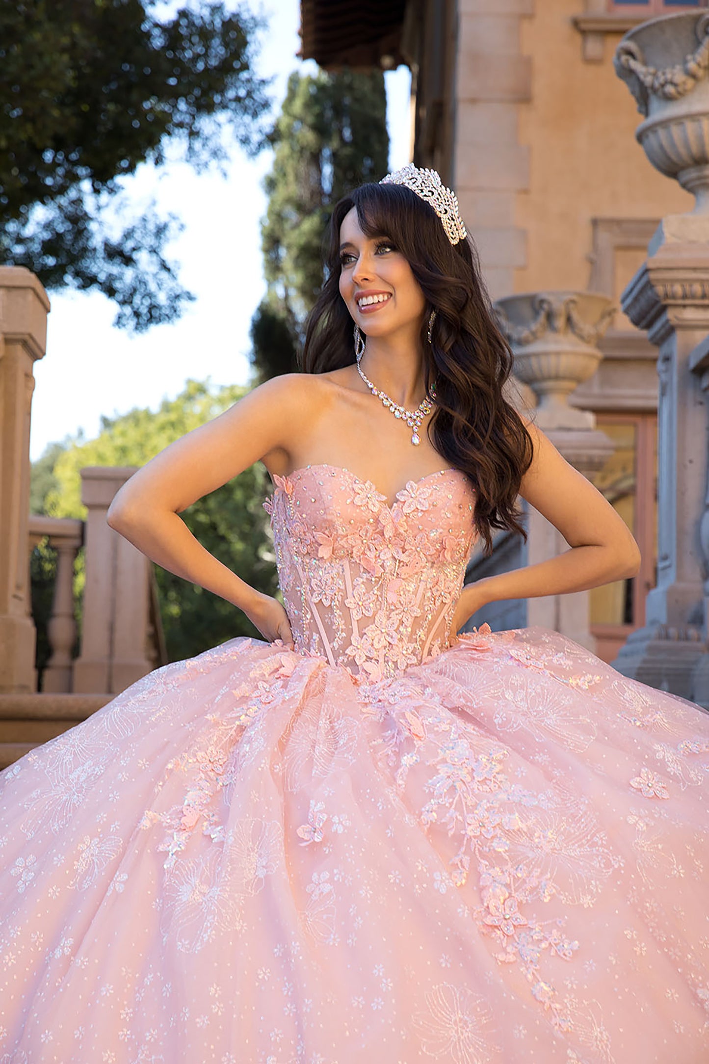 Quinceañera | Blush Long Train Ballgown with 3D Flowers, Rhinestones, and Embroidered Details with Detachable Ruffle Sleeves | Analia dress front view with tiara