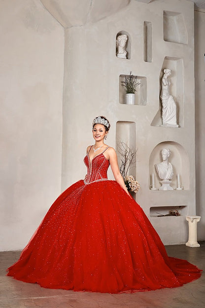 Woman in a red ball gown standing in a room with decorative wall shelves.