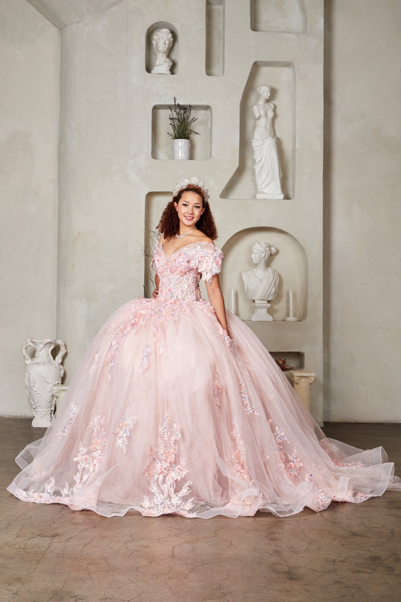 Woman wearing blush ball gown with crystal-beaded embroidered bodice, 3D floral appliqués, and voluminous full skirt
