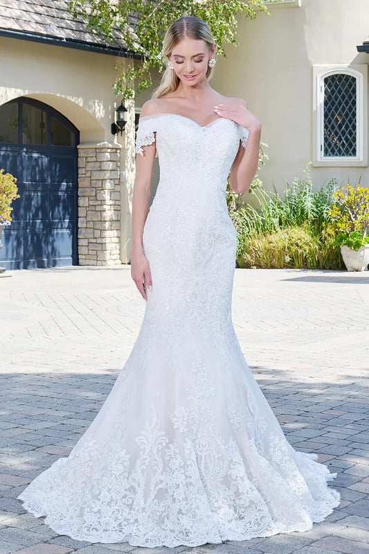 Front full-length view of an ivory and cream mermaid wedding dress featuring a sweetheart neckline, cut-away shoulder sleeves, and an intricately embroidered jeweled bodice.