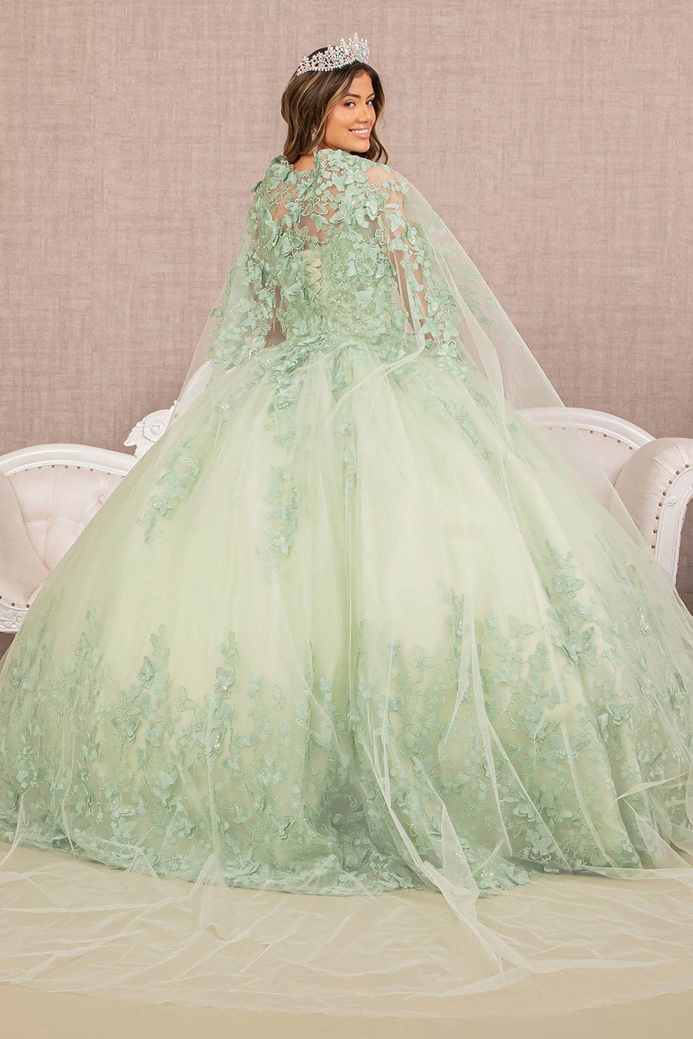 Side Angle of Sage Paloma Quince Ball Gown Featuring 3D Butterfly Appliqués and Flowing Mesh Cape