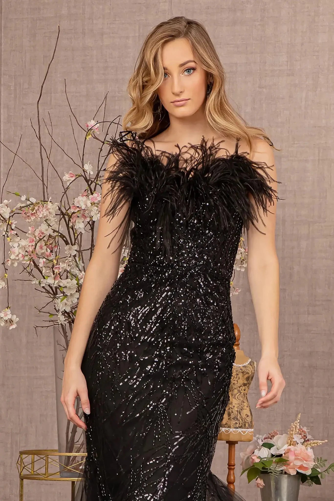 Front close-up upper view of  Black sequin sweetheart trumpet prom dress with feather embellishments