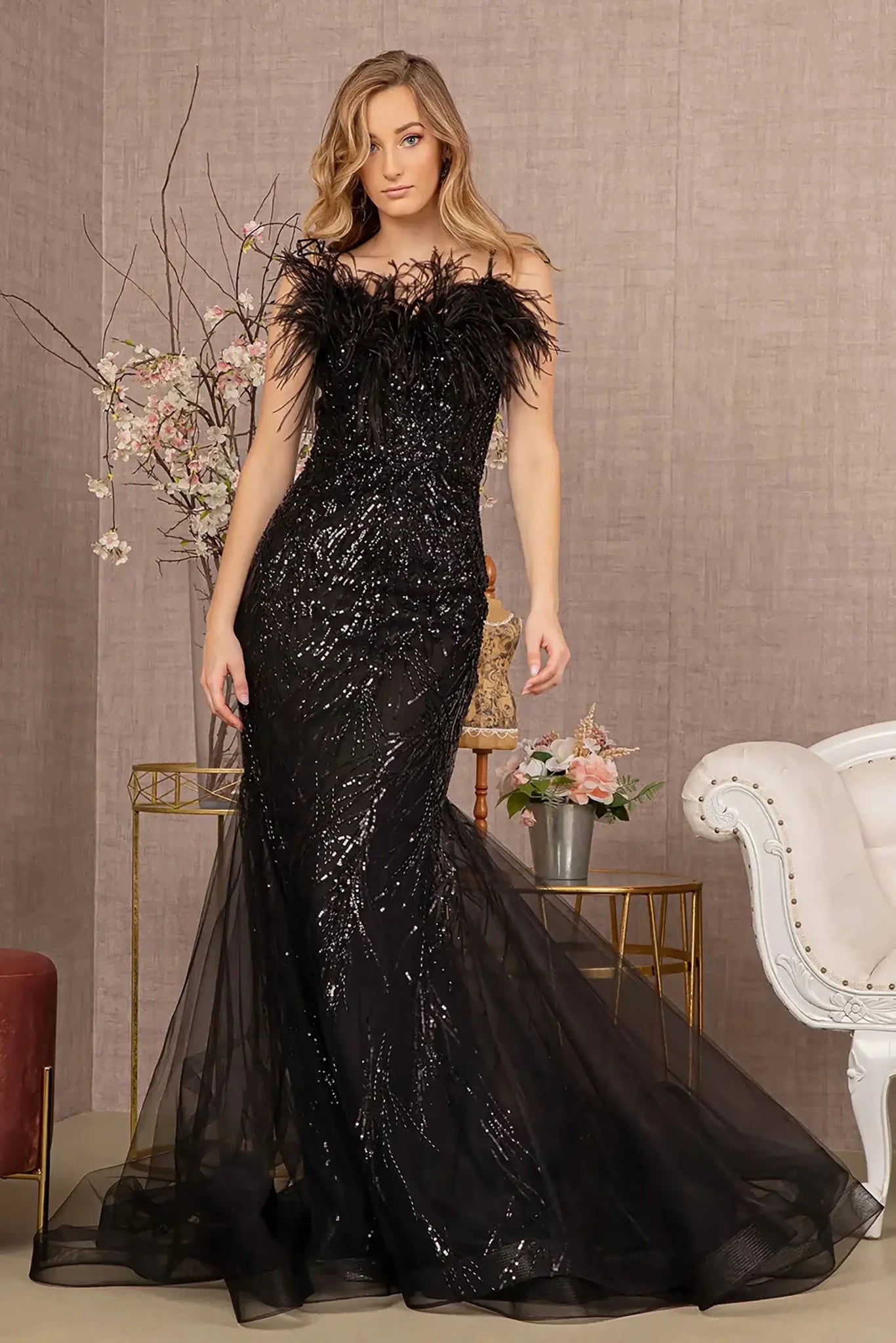 Front full-length view of a  Black sequin sweetheart trumpet prom dress with feather embellishments